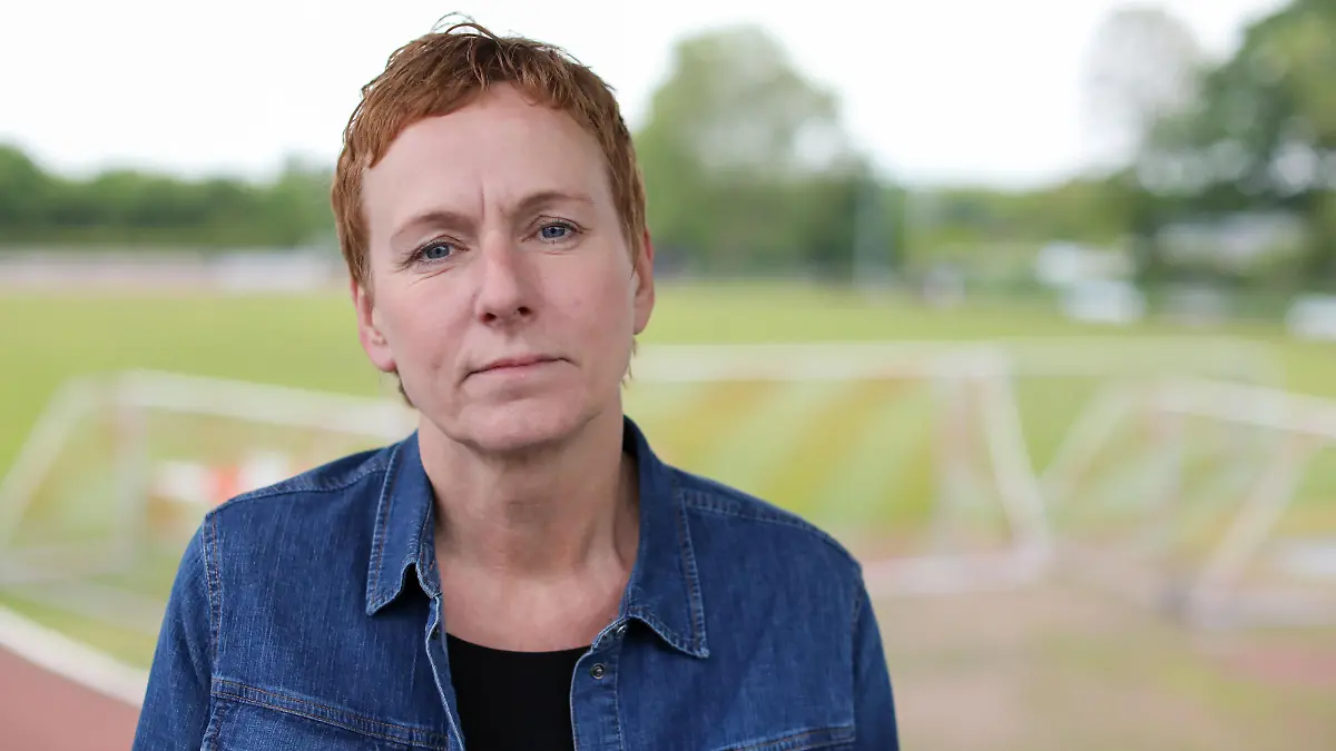 Ute Groth, Vorsitzende des DJK Tusa 06 Düsseldorf, steht am Fußballplatz des Vereins