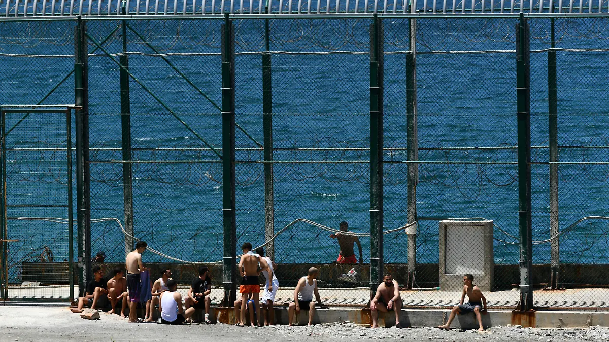 Men and children from Morocco sit after entering into the Spanish territory at the border of Morocco and Spain, at the Spanish enclave of Ceuta on Monday, May 17, 2021. Authorities in Spain say that around 1,000 Moroccan migrants have crossed into Spanish territory (Antonio Sempere/Europa Press via AP)