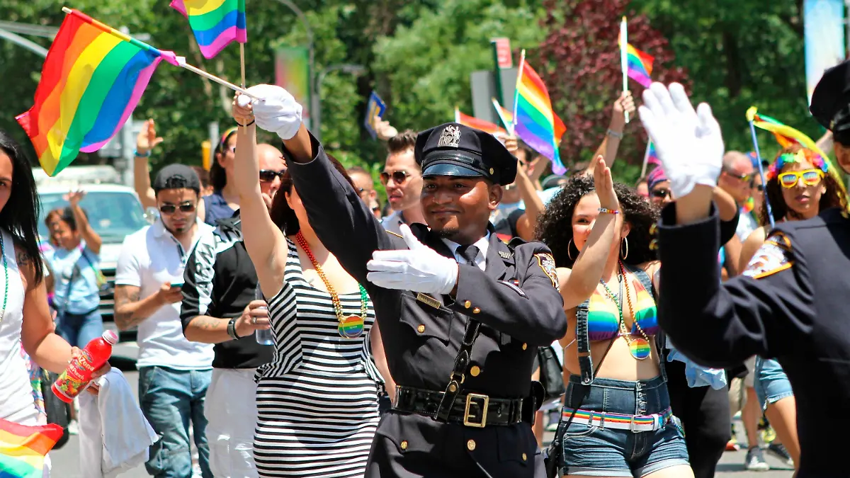 FILE - In this Sunday, June 29, 2014 file photo, NYPD police officers march along Fifth Avenue during the gay pride parade in New York. Organizers of New York City’s Pride events said Saturday, May 15, 2021 they are banning police and other law enforcement from marching in their huge annual parade until at least 2025 and will also seek to keep on-duty officers a block away from the celebration of LGBTQ people and history. (AP Photo/Julia Weeks, File)