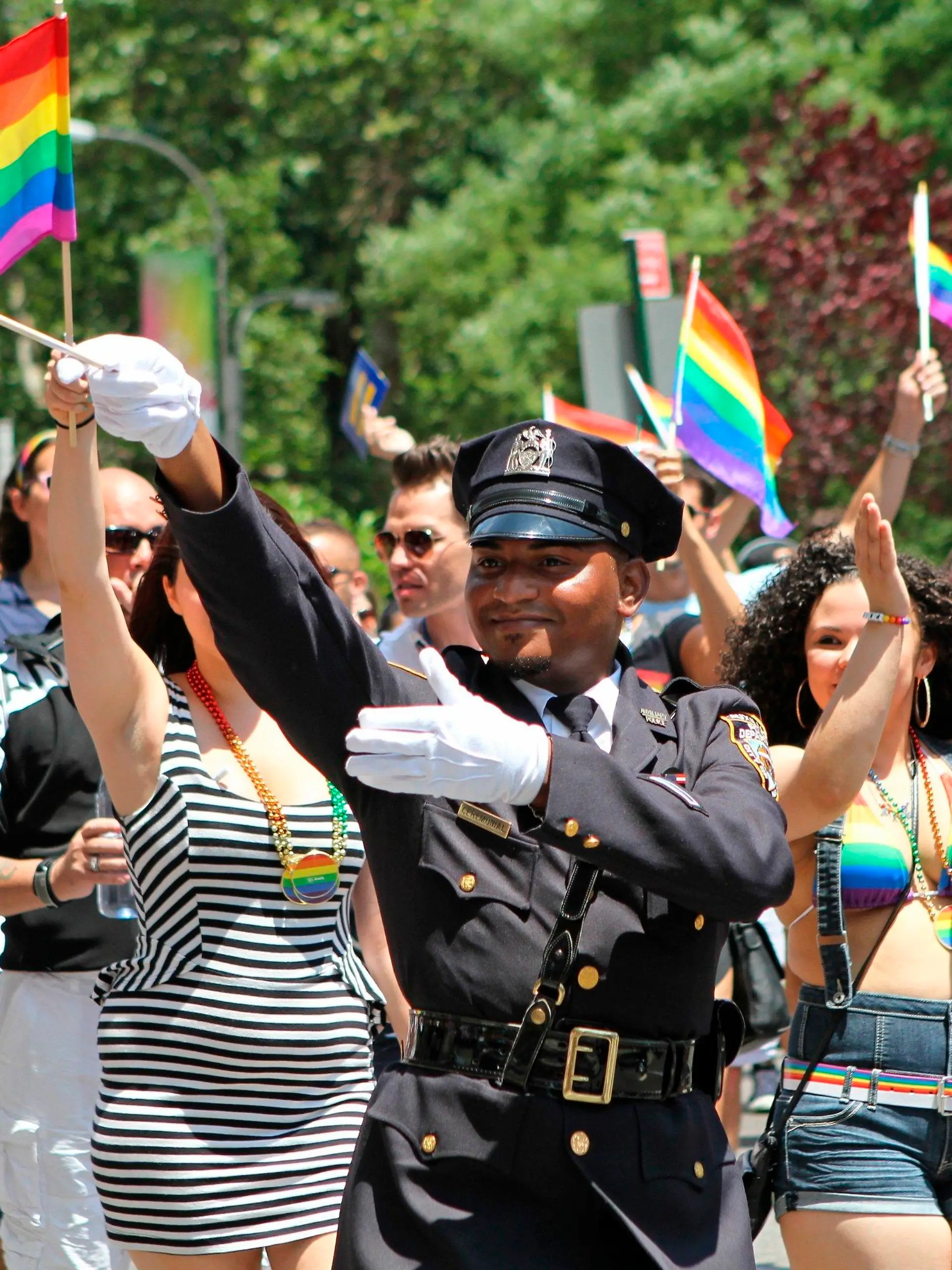 FILE - In this Sunday, June 29, 2014 file photo, NYPD police officers march along Fifth Avenue during the gay pride parade in New York.  Organizers of New York City’s Pride events said Saturday, May 15, 2021 they are banning police and other law enforcement from marching in their huge annual parade until at least 2025 and will also seek to keep on-duty officers a block away from the celebration of LGBTQ people and history. (AP Photo/Julia Weeks, File)