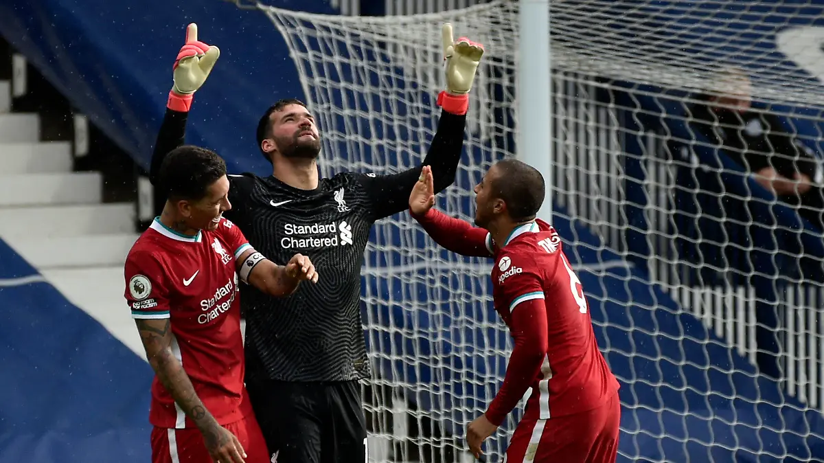 Liverpool's goalkeeper Alisson, center, celebrates with teammates after scoring his side's second goal during the English Premier League soccer match between West Bromwich Albion and Liverpool at the Hawthorns stadium in West Bromwich, England, Sunday, May 16, 2021. (AP Photo/Rui Vieira, Pool)