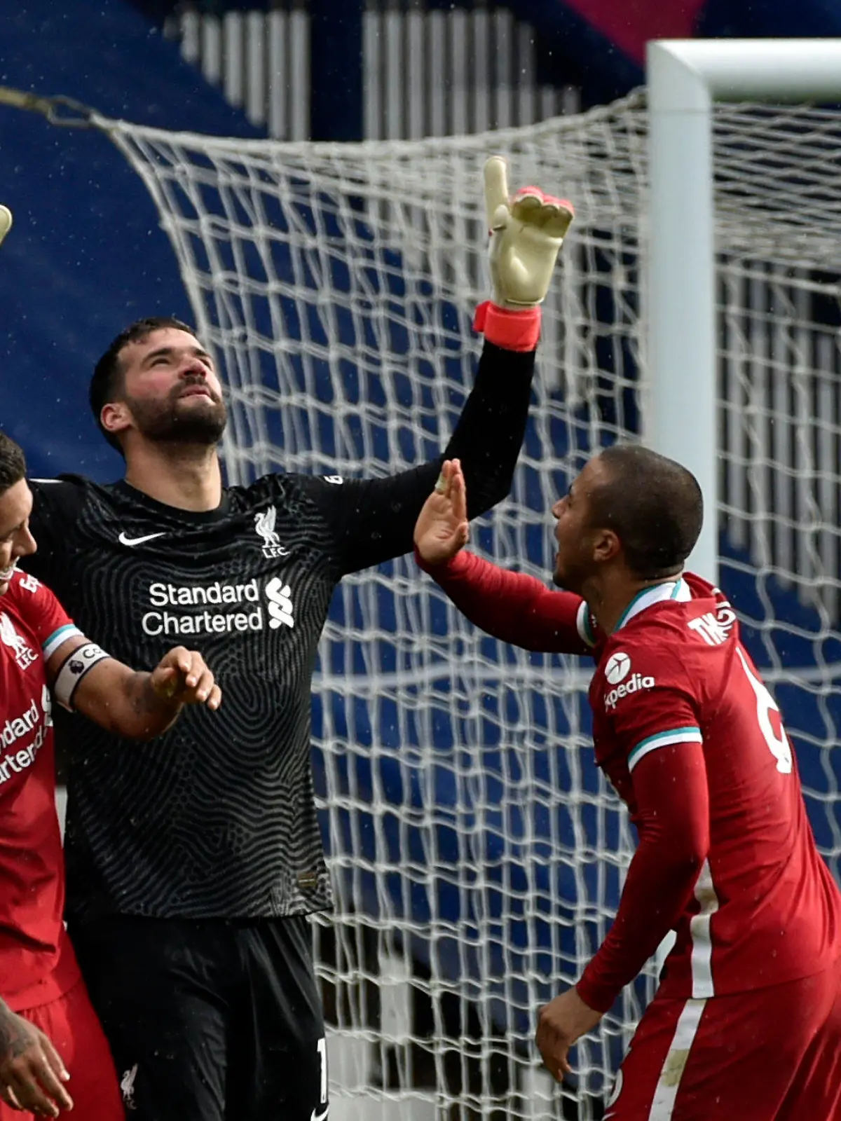 Liverpool's goalkeeper Alisson, center, celebrates with teammates after scoring his side's second goal during the English Premier League soccer match between West Bromwich Albion and Liverpool at the Hawthorns stadium in West Bromwich, England, Sunday, May 16, 2021. (AP Photo/Rui Vieira, Pool)