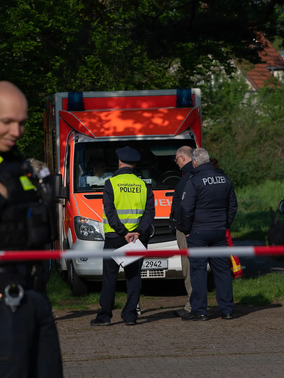 15.05.2021, Berlin: Polizeibeamte stehen an einem Absperrband unweit einer Parkanlage an der Idsteiner Straße Ecke Seibtweg in Berlin-Zehlendorf . Dort wurde am frühen Morgen ein schwer verletzter Mann gefunden.  Bei einem Streit ist am frühen Samstagmorgen in Berlin-Zehlendorf ein 19-Jähriger ums Leben gekommen. Wie Polizei mitteilte, seien es nach aktuellen Erkenntnissen kurz nach 3.00 Uhr in dem kleinen Park an der Idsteiner Straße Ecke Seibtweg zwischen einem Unbekannten und dem 19-Jährigen zu Streitigkeiten gekommen. Dabei sei der junge Mann schwer verletzt worden. Eine vom Rettungsdienst eingeleitete Reanimation sei erfolglos geblieben. Foto: Paul Zinken/dpa-Zentralbild/dpa +++ dpa-Bildfunk +++