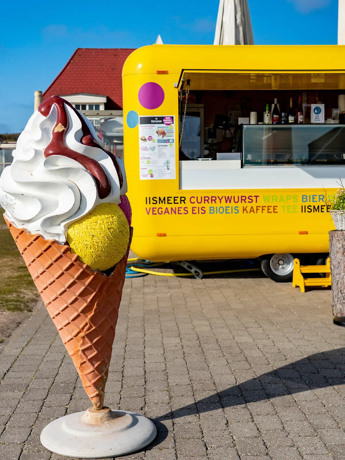 23.04.2021, Schleswig-Holstein, Wenningstedt: Ein Mann steht auf der Strandpromenade vor Imbisswagen, in dem Eis und Snacks verkauft werden. Die Gemeinde Sylt stimmt für eine Modellregion-Teilnahme. In vier Modellregionen in Schleswig-Holstein sollen die Tourismusbetriebe eine schrittweise Lockerung der Corona-Schutzmaßnahmen erproben. Foto: Axel Heimken/dpa +++ dpa-Bildfunk +++