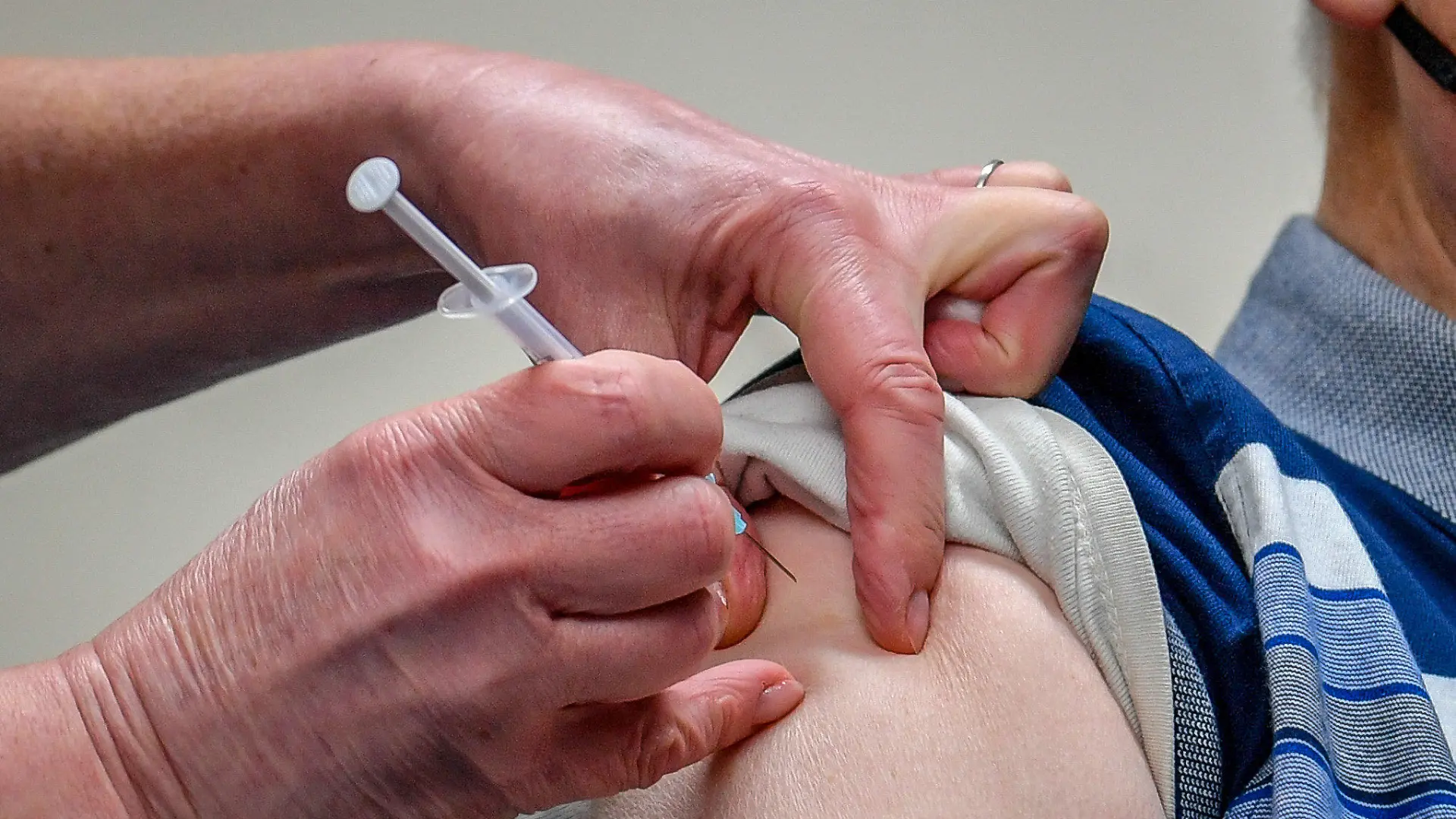 ARCHIV - 04.01.2021, Großbritannien, Merthyr Tydfil: Ein Patient wird mit dem von der Universität Oxford und dem Pharmakonzern Astrazeneca produzierten Corona-Impfstoffs in der Arztpraxis Pontcae geimpft. Wer zwei unterschiedliche Corona-Impfstoffe bei seiner Erst- und Zweitimpfung erhält, hat mit höherer Wahrscheinlichkeit milde und moderate Nebenwirkungen nach der zweiten Dosis. (zu dpa «Studie: Nebenwirkungen bei gemischter Corona-Impfung etwas häufiger») Foto: Ben Birchall/PA Wire/dpa +++ dpa-Bildfunk +++