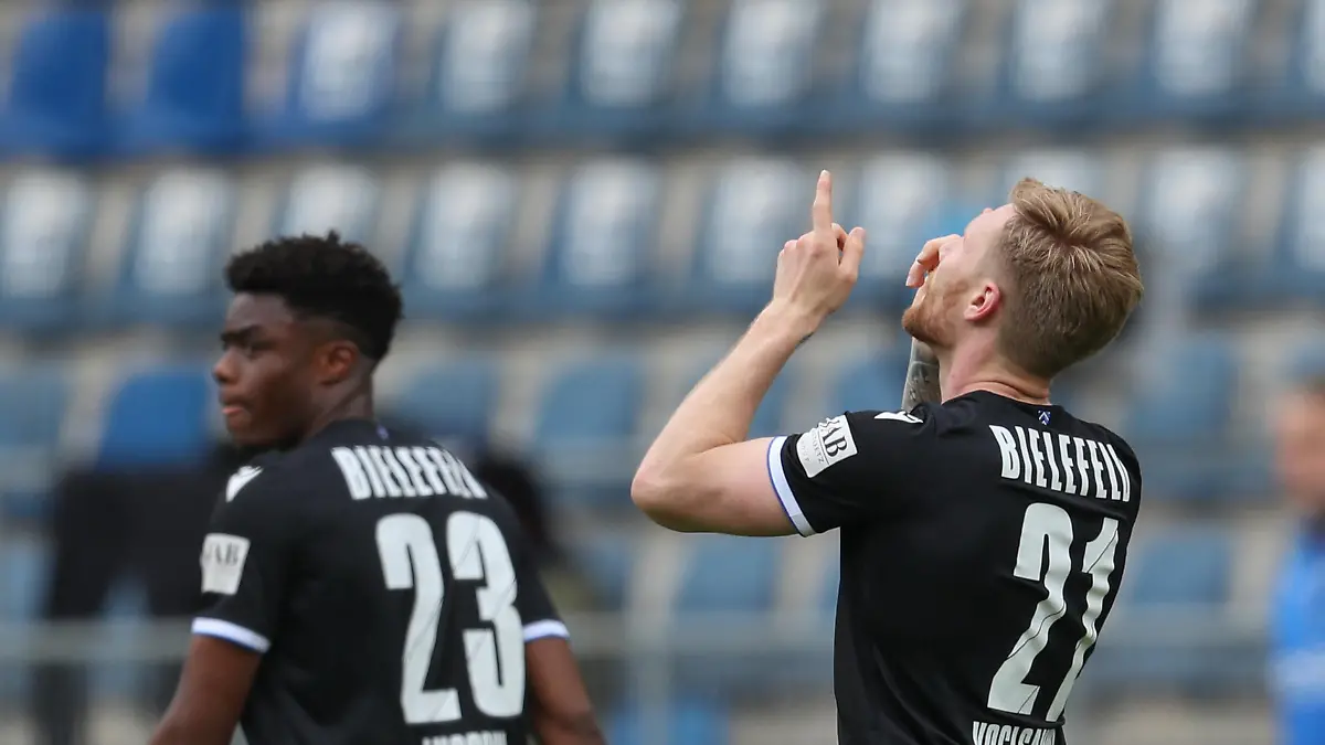 15.05.2021, Nordrhein-Westfalen, Bielefeld: Fußball: Bundesliga, Arminia Bielefeld - TSG 1899 Hoffenheim, 33. Spieltag in der Schüco-Arena. Bielefelds Torschütze Andreas Voglsammer (r) feiert seinen Treffer zum 1:1 mit Anderson Lucoqui (l). Foto: Friso Gentsch/dpa - WICHTIGER HINWEIS: Gemäß den Vorgaben der DFL Deutsche Fußball Liga bzw. des DFB Deutscher Fußball-Bund ist es untersagt, in dem Stadion und/oder vom Spiel angefertigte Fotoaufnahmen in Form von Sequenzbildern und/oder videoähnlichen Fotostrecken zu verwerten bzw. verwerten zu lassen. +++ dpa-Bildfunk +++