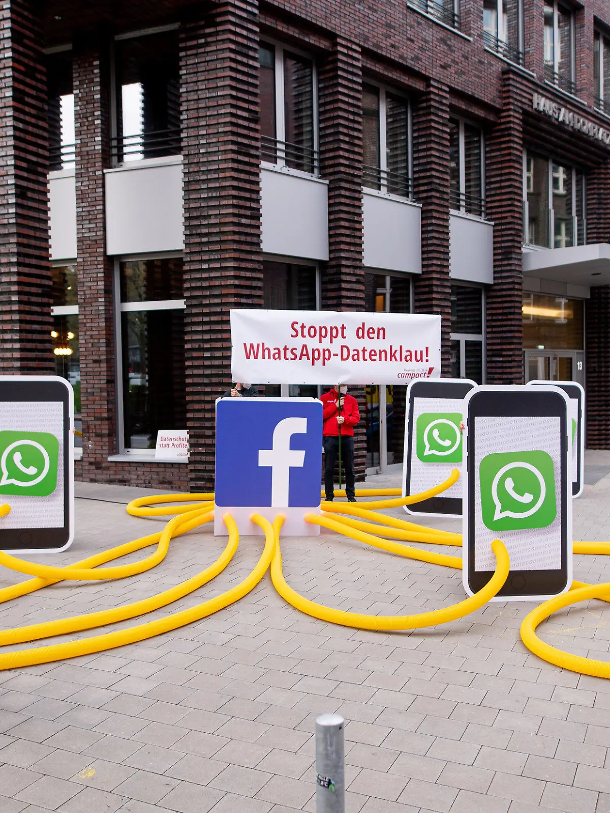 14.05.2021, Hamburg: Aktivisten des Kampagnennetzwerks Campact demonstrieren vor dem Sitz des Internet-Konzerns Facebook unter dem Motto «Stoppt den WhatsApp-Datenklau» gegen neue Nutzungsbedingungen der Kommunikations-App «WhatsApp». Foto: Daniel Reinhardt/dpa +++ dpa-Bildfunk +++