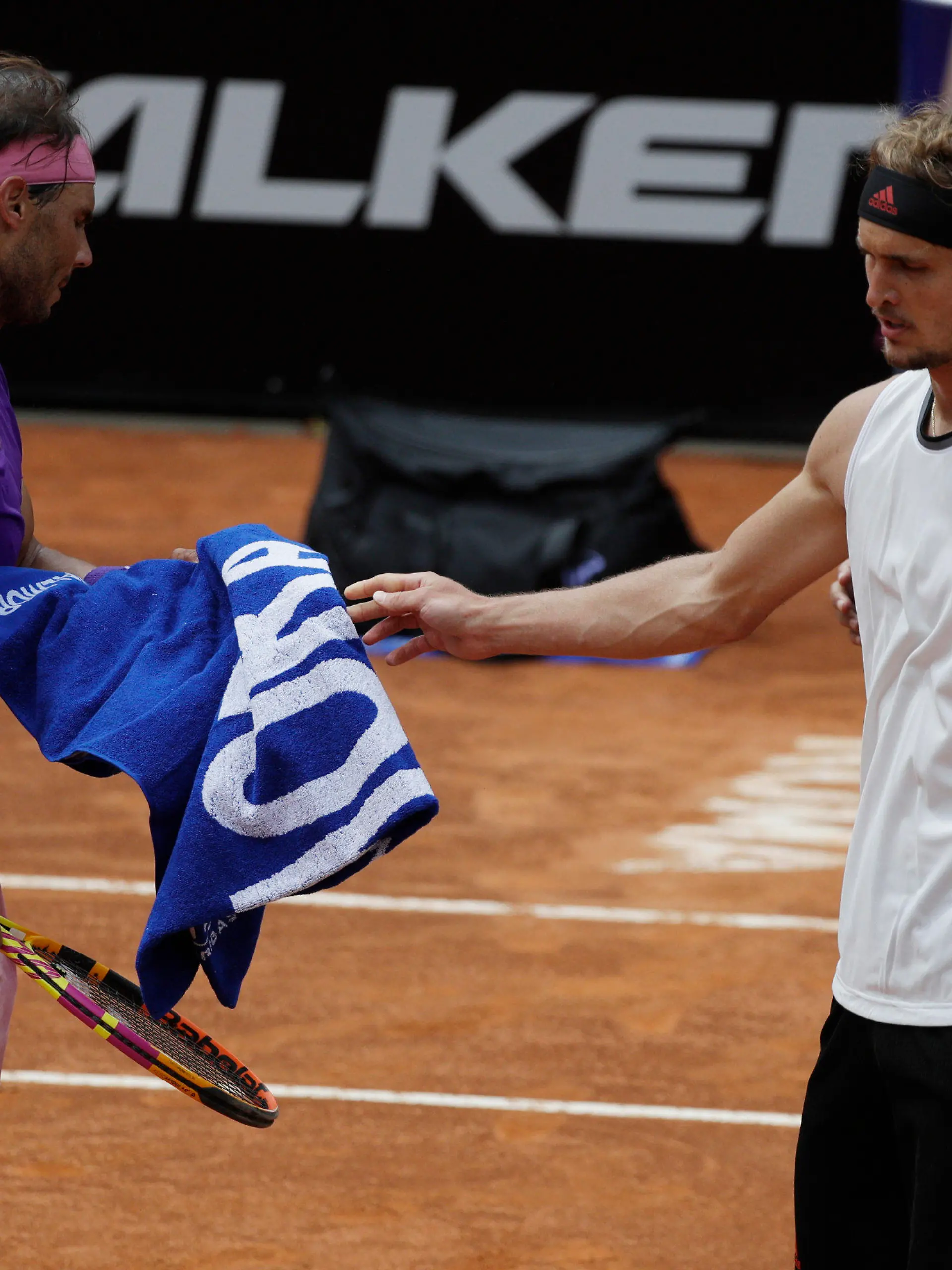 14.05.2021, Italien, Rom: Tennis: ATP-Tour - Rom, Einzel, Herren, Viertelfinale, A. Zverev (Deutschland) - Nadal (Spanien): Alexander Zverev (r) reicht dem Rafael Nadal ein Handtuch, nachdem dieser gestützt ist. Foto: Gregorio Borgia/AP/dpa +++ dpa-Bildfunk +++