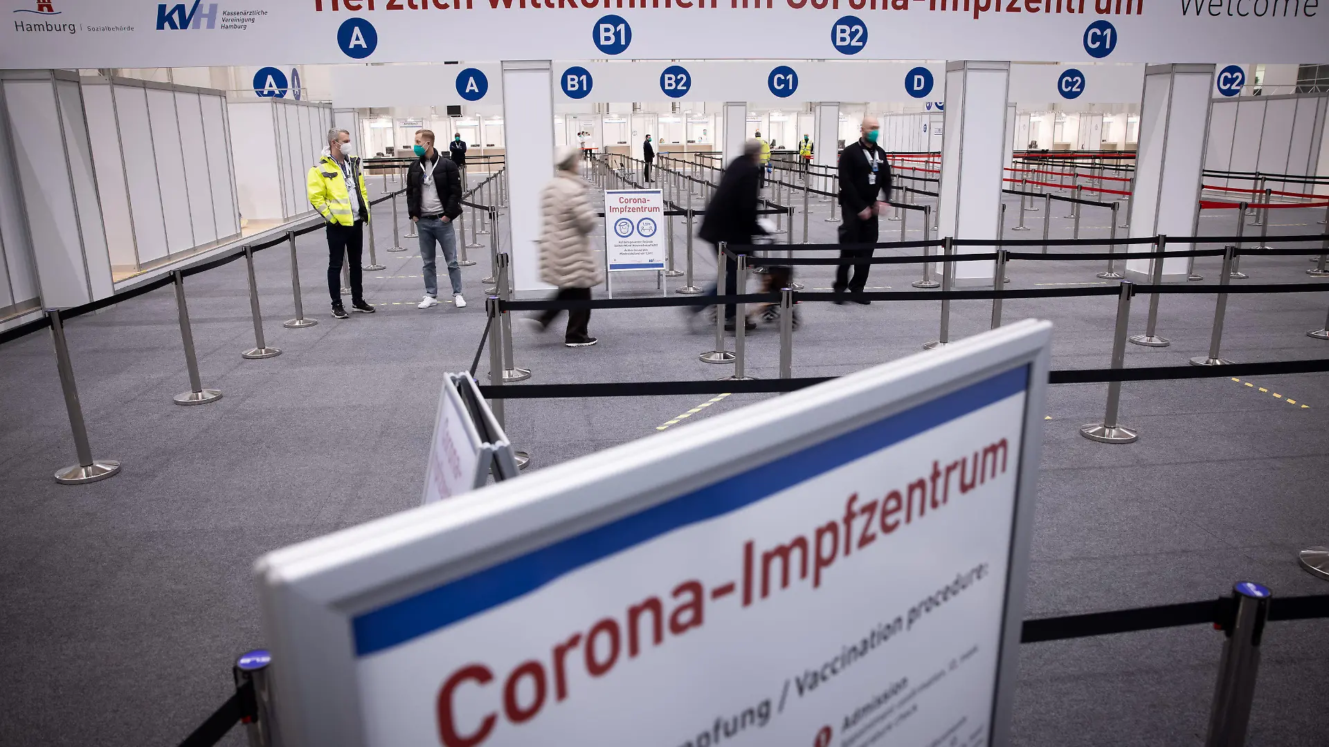 ARCHIV - 26.01.2021, Hamburg: Zwei Senioren (M) sind im Eingangsbereich des Corona-Impfzentrums in den Hamburger Messehallen auf dem Weg zur Impfung. Dort erfolgt das Gros der Hambuger Corona-Schutzimpfungen. (Zu dpa «Hamburger Krankenhäuser steigen in Impfkampagne ein») Foto: Christian Charisius/dpa +++ dpa-Bildfunk +++