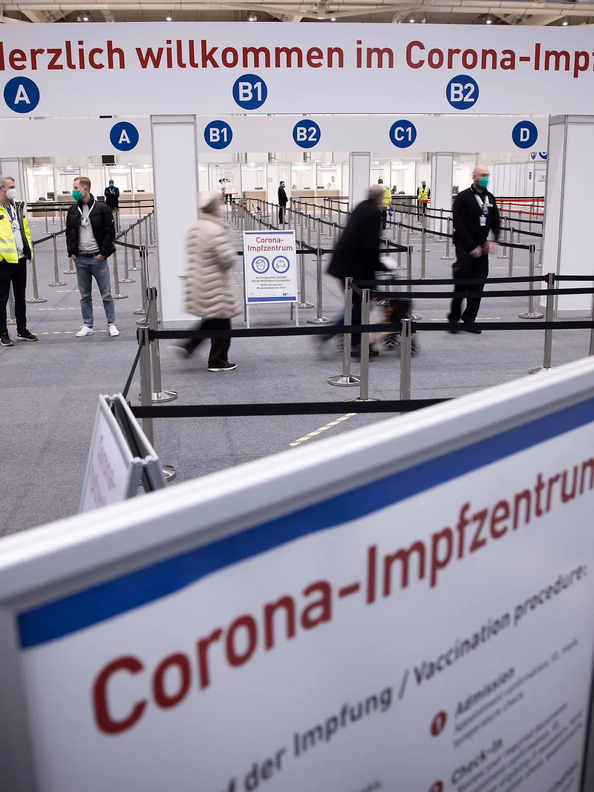 ARCHIV - 26.01.2021, Hamburg: Zwei Senioren (M) sind im Eingangsbereich des Corona-Impfzentrums in den Hamburger Messehallen auf dem Weg zur Impfung. Dort erfolgt das Gros der Hambuger Corona-Schutzimpfungen. (Zu dpa «Hamburger Krankenhäuser steigen in Impfkampagne ein») Foto: Christian Charisius/dpa +++ dpa-Bildfunk +++
