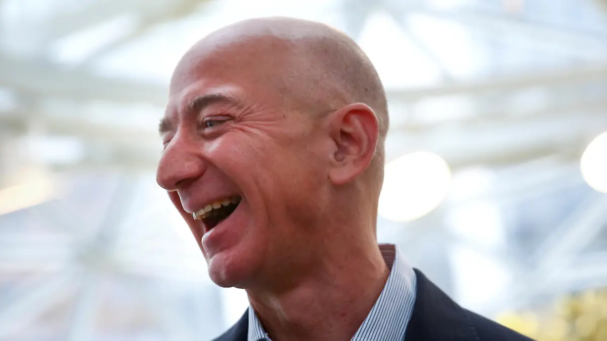 FILE PHOTO: FILE PHOTO: Amazon founder and CEO Jeff Bezos laughs as he talks to the media while touring the new Amazon Spheres during the grand opening at Amazon's Seattle headquarters in Seattle, Washington, U.S., January 29, 2018. REUTERS/Lindsey Wasson/File Photo/File Photo
