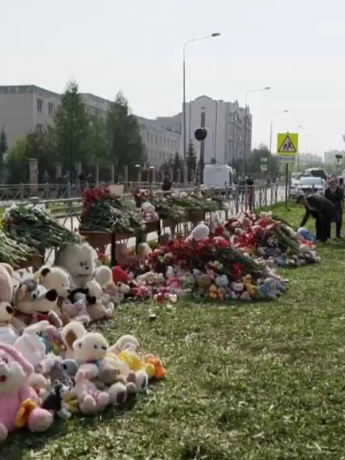 Vor der Schule in Kasan haben Trauernde Blumen und Kuscheltiere abgelegt.