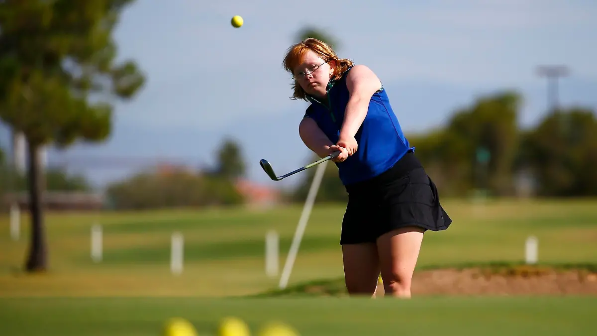 In this Aug. 28, 2019, file photo, Amy Bockerstette practices with her teaching pro at Palmbrook Country Club in Sun City, Ariz. Bockerstette is set to become the first person with Down syndrome to compete in a national collegiate athletic championship. (AP Photo/Ross D. Franklin, File)