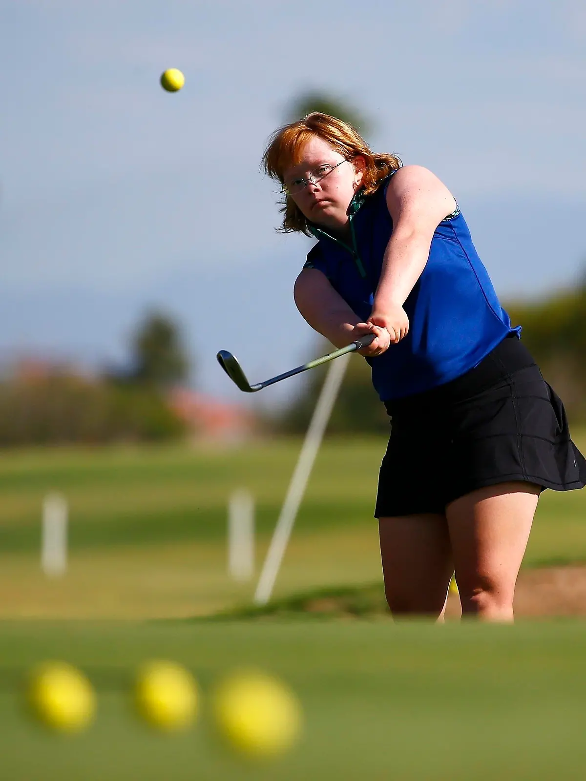 In this Aug. 28, 2019, file photo, Amy Bockerstette practices with her teaching pro at Palmbrook Country Club in Sun City, Ariz. Bockerstette is set to become the first person with Down syndrome to compete in a national collegiate athletic championship. (AP Photo/Ross D. Franklin, File)