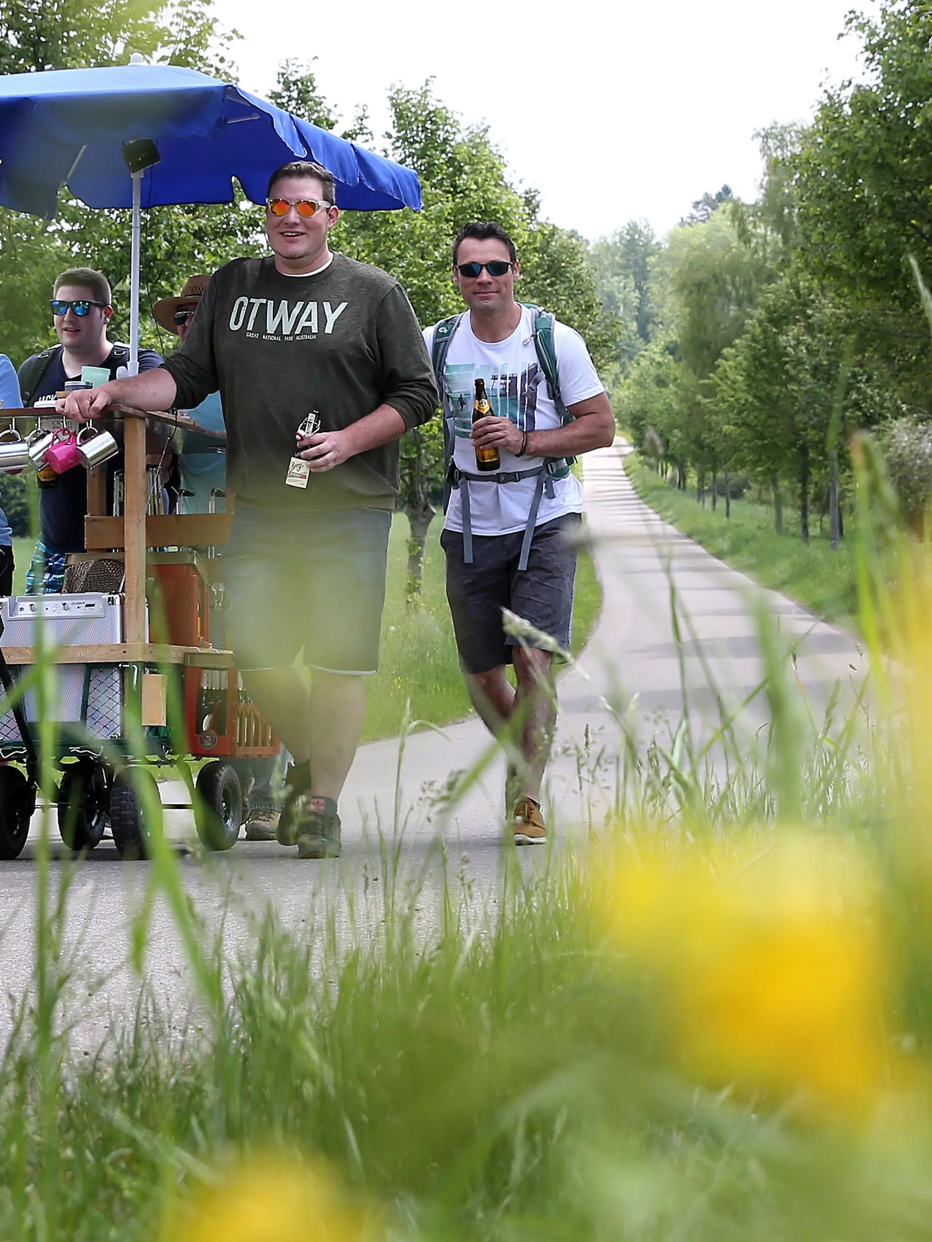 Eine Gruppe Männer ist am 25.05.2017 bei ihrer Vatertagstour mit Handwagen und einem Sonnenschirm bei Erisdorf (Baden-Württemberg) unterwegs. Foto: Thomas Warnack/dpa | Verwendung weltweit