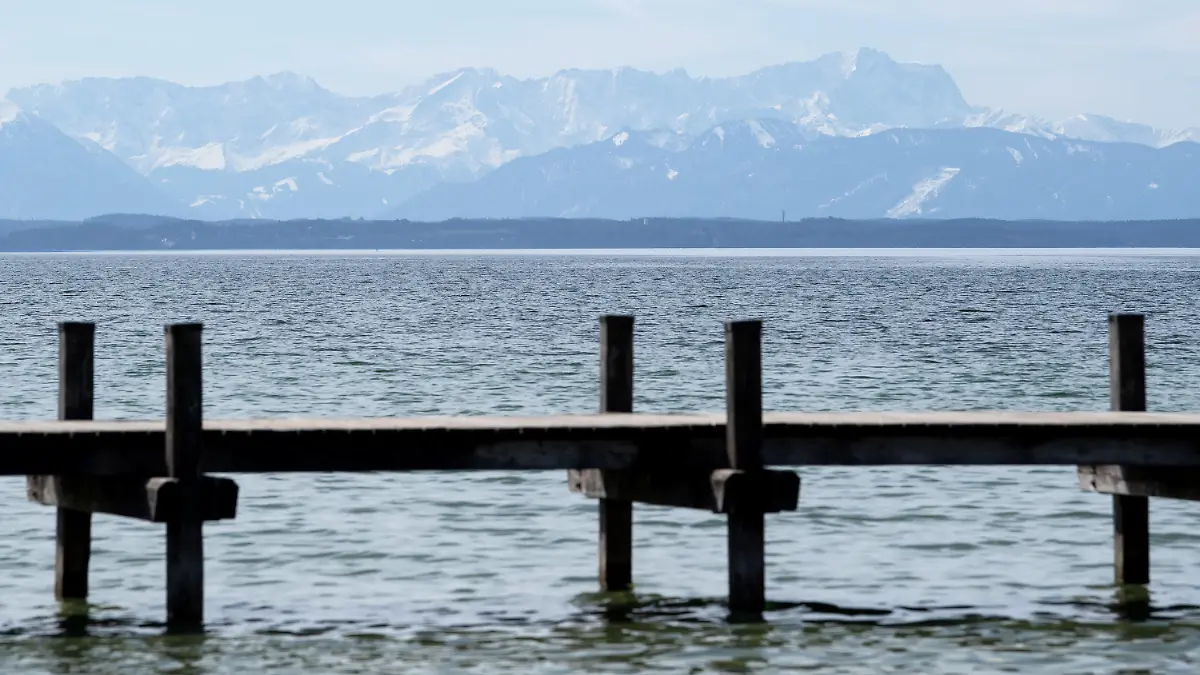 28.03.2021, Bayern, Starnberg: Ein abgesperrter Steg ist am Starnberger See zu sehen. Im Hintergrund zeichnen sich die Alpen mit der Zugspitze ab. Foto: Sven Hoppe/dpa +++ dpa-Bildfunk +++
