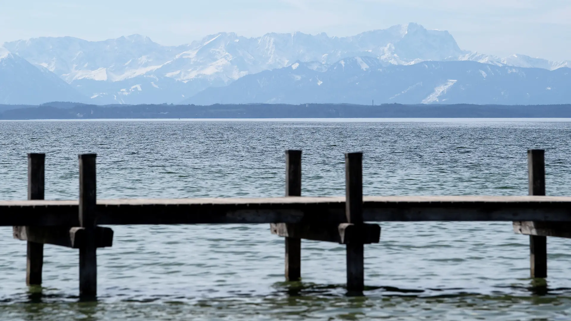 28.03.2021, Bayern, Starnberg: Ein abgesperrter Steg ist am Starnberger See zu sehen. Im Hintergrund zeichnen sich die Alpen mit der Zugspitze ab. Foto: Sven Hoppe/dpa +++ dpa-Bildfunk +++