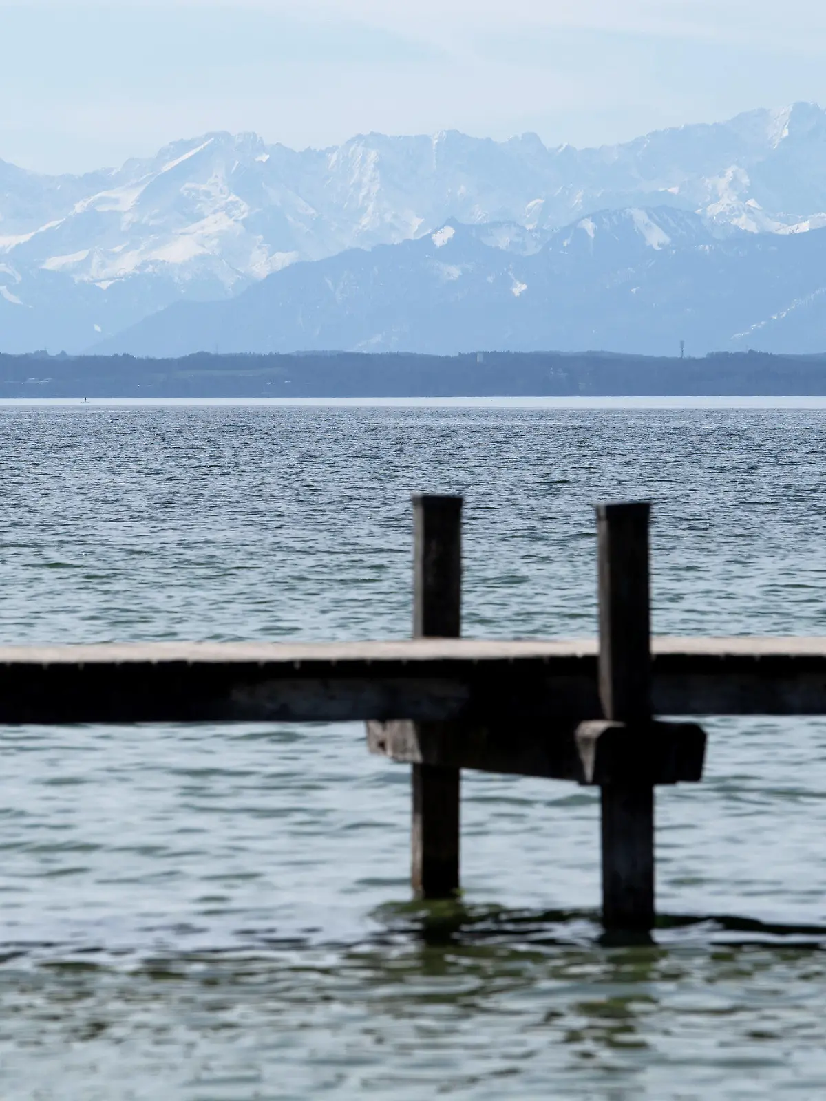 28.03.2021, Bayern, Starnberg: Ein abgesperrter Steg ist am Starnberger See zu sehen. Im Hintergrund zeichnen sich die Alpen mit der Zugspitze ab. Foto: Sven Hoppe/dpa +++ dpa-Bildfunk +++