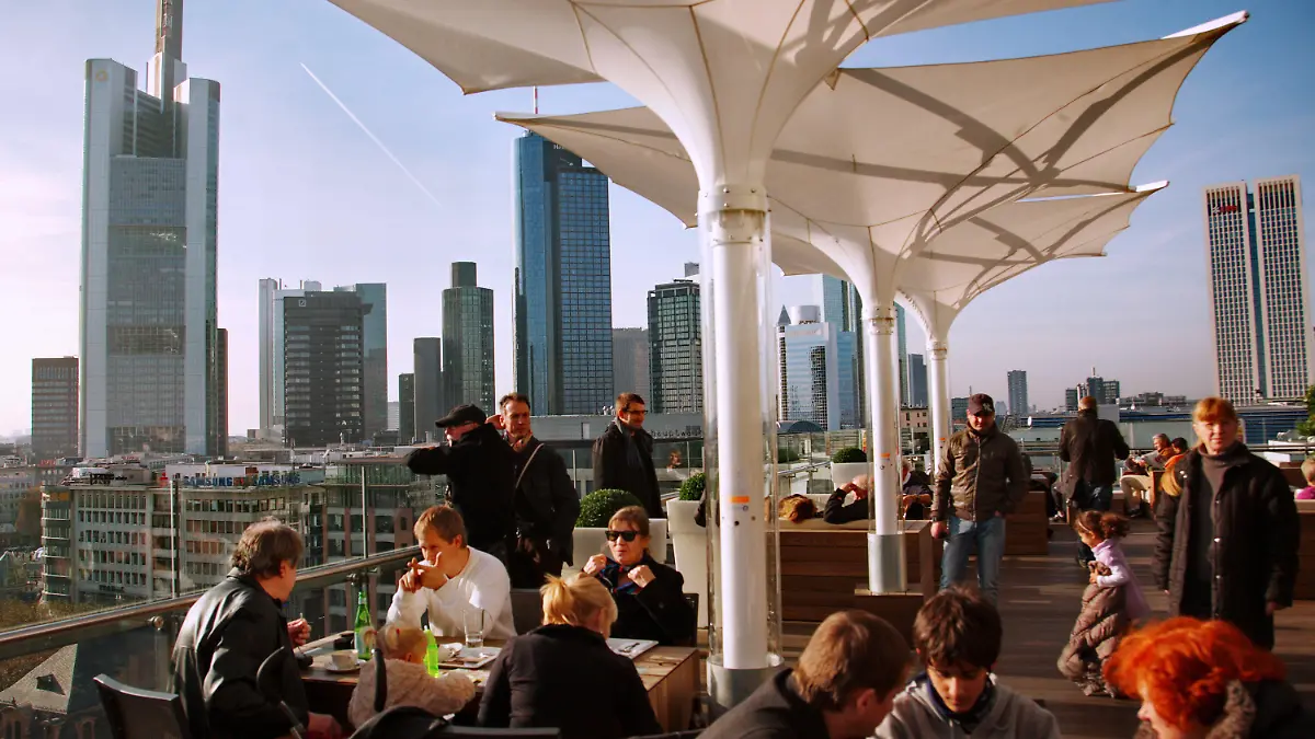 Cafebesucher und Touristen genießen den warmen Novembertag auf einer Dachterrasse bei strahlendem Sonnenschein in Frankfurt am Main am Samstag (19.11.2011). Im Hintergrund sind die Hochhäuser der Banken zu sehen. Nach Aussagen der Meteorologen soll das Wetter in den nächsten Tagen in Hessen immer wieder auch sonnige Abschnitte bringen, bei Höchsttemperaturen um 10 Grad. Foto: Wolfram Steinberg dpa/lhe +++(c) dpa - Bildfunk+++