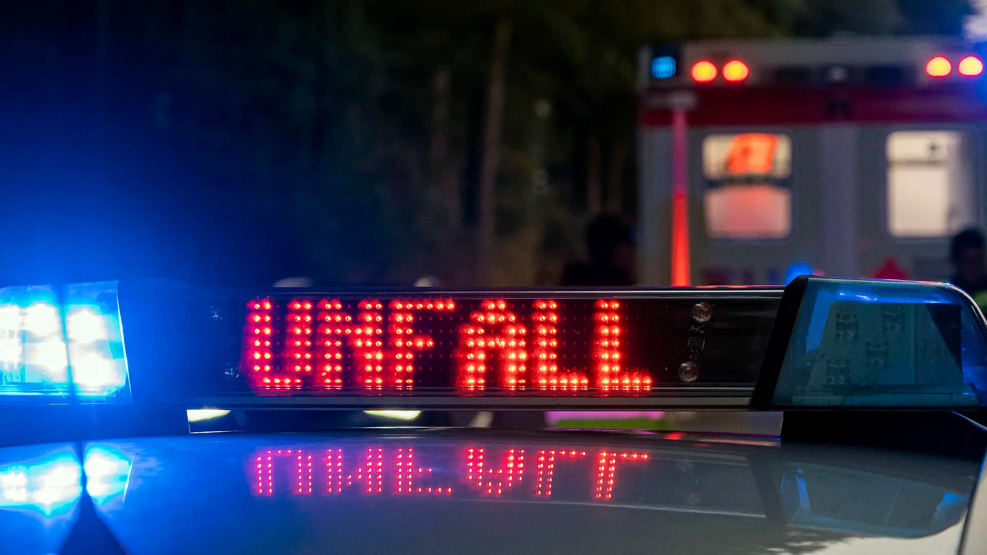  Osnabrueck, Deutschland 08. Oktober 2021: Ein Einsatzfahrzeug, Streifenwagen, der Polizei mit Blaulicht und dem Schriftzug Unfall im Display. Bei Dunkelheit erkennt man im Hintergrund einen Rettungswagen, RTW. Niedersachsen *** Osnabrueck, Germany 08 October 2021 A police car, patrol car, with blue light and the word accident in the display In the dark you can see an ambulance, RTW Lower Saxony, in the background. Copyright: xFotostandx/xReissx