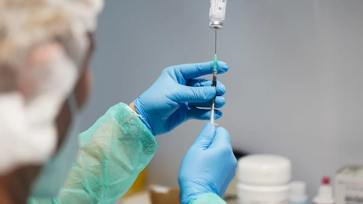 10.05.2021, Berlin: Eine Spritze mit dem Impfstoff Moderna wird in den Impfräumen des Modellprojekts "Betriebliches Impfen KRTIS" bei Berlin-Chemie aufgezogen. Berlin hat ein Pilotprojekt zum Impfen in Betrieben gestartet. Foto: Jörg Carstensen/dpa - ACHTUNG: LOT-Nummer gepixelt +++ dpa-Bildfunk +++