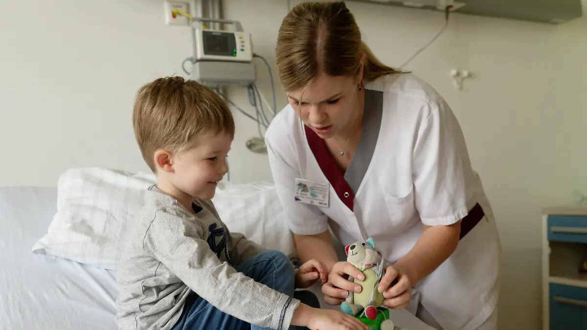 10.02.2020, Nordrhein-Westfalen, Mönchengladbach: Kinderkrankenschwester Sylvia Croonenbroeck (r) spielt im Zentrum für Kinder- und Jugendmedizin im Elisabeth-Krankenhaus Rheydt mit dem vier Jahre alten Lönne. Die Kinderärzte in Deutschland diagnostizieren den «schleichenden Tod der Kinderkrankenschwester». Die Schuld sehen sie beim neuen Pflegeberufegesetz, das dem beliebigen Einsatz von Pflegepersonal Tür und Tor öffne. (Zu dpa: «Streit um Pflegeberufe - Auslaufmodell Kinderkrankenschwester?») Foto: Henning Kaiser/dpa +++ dpa-Bildfunk +++