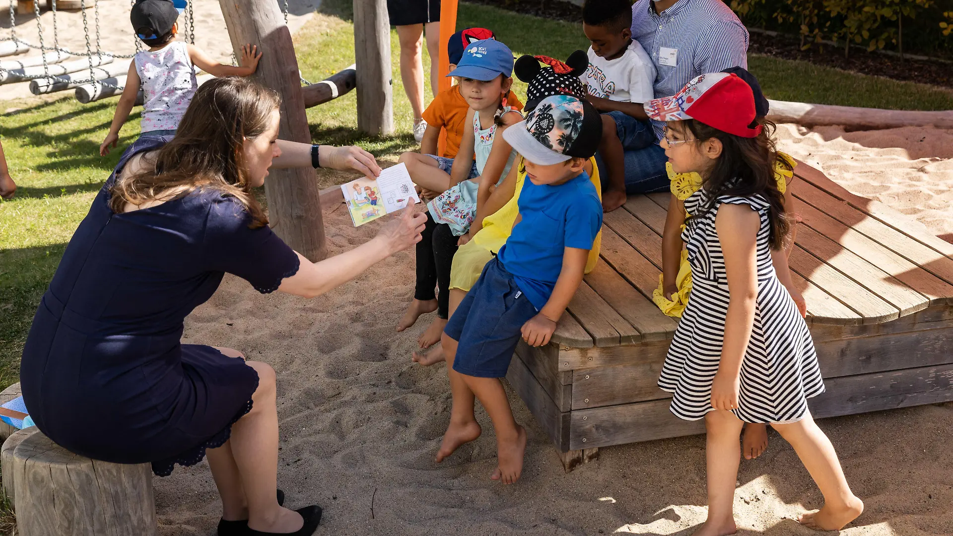 06.08.2020, Hamburg: Melanie Leonhard (SPD), Hamburgs Senatorin für Arbeit, Gesundheit, Soziales, Familie und Integration, liest mit Kinden der Kita Jenfelder Au in Hamburg das Pixi-Buch ·Corona und der Elefantenabstand·. Heute startet in der Hansestadt der Kita-Regelbetrieb für rund 90.000 Kita-Kinder, die wieder in die Einrichtungen gehen und dort die volle Zeit betreut werden können. Foto: Ulrich Perrey/dpa +++ dpa-Bildfunk +++