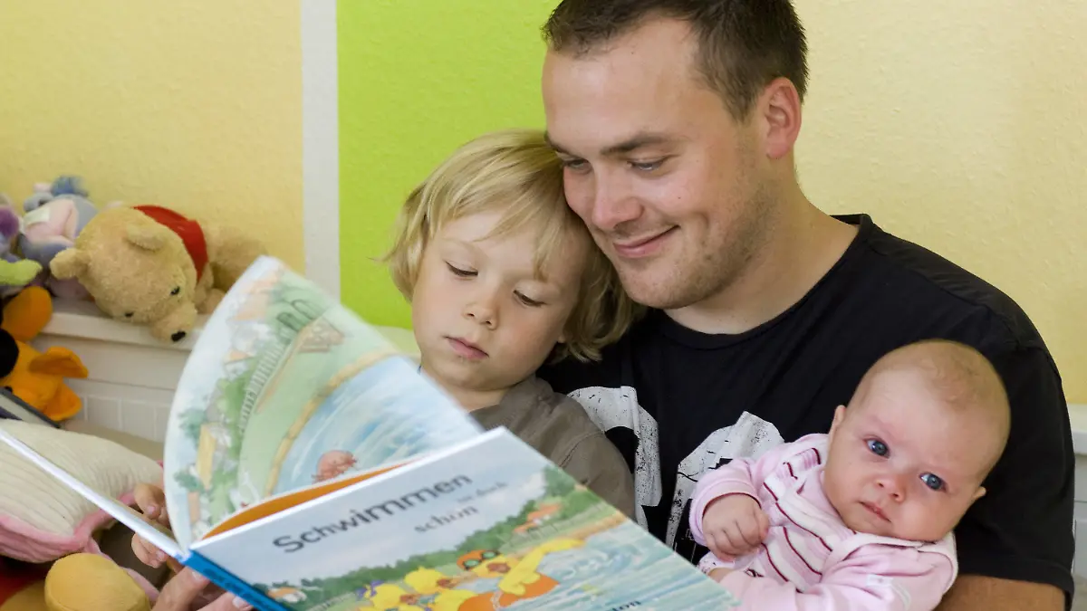 ARCHIV - 17.07.2008, Brandenburg, Frankfurt:oder: Andreas Lange liest seinem Sohn Janne und seiner Totcher Fiona vor. Der Vater hat drei Monate Elternzeit genommen. Väter, die in Elternzeit gehen, verbringen mehr Zeit mit ihren Kindern und machen mehr im Haushalt. Dieser Effekt hält auch noch Jahre nach dem Ende der Pause an, wie eine Studie des RWI-Leibniz-Instituts für Wirtschaftsforschung in Essen zeigt. Foto: Patrick Pleul/dpa-Zentralbild/dpa +++ dpa-Bildfunk +++