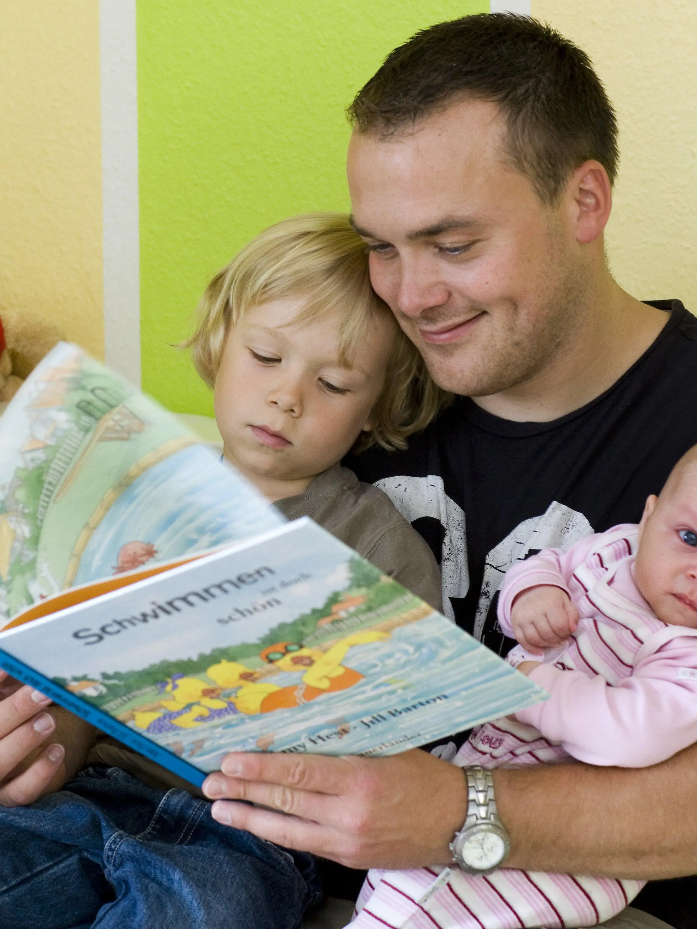 ARCHIV - 17.07.2008, Brandenburg, Frankfurt:oder: Andreas Lange liest seinem Sohn Janne und seiner Totcher Fiona vor. Der Vater hat drei Monate Elternzeit genommen. Väter, die in Elternzeit gehen, verbringen mehr Zeit mit ihren Kindern und machen mehr im Haushalt. Dieser Effekt hält auch noch Jahre nach dem Ende der Pause an, wie eine Studie des RWI-Leibniz-Instituts für Wirtschaftsforschung in Essen zeigt. Foto: Patrick Pleul/dpa-Zentralbild/dpa +++ dpa-Bildfunk +++