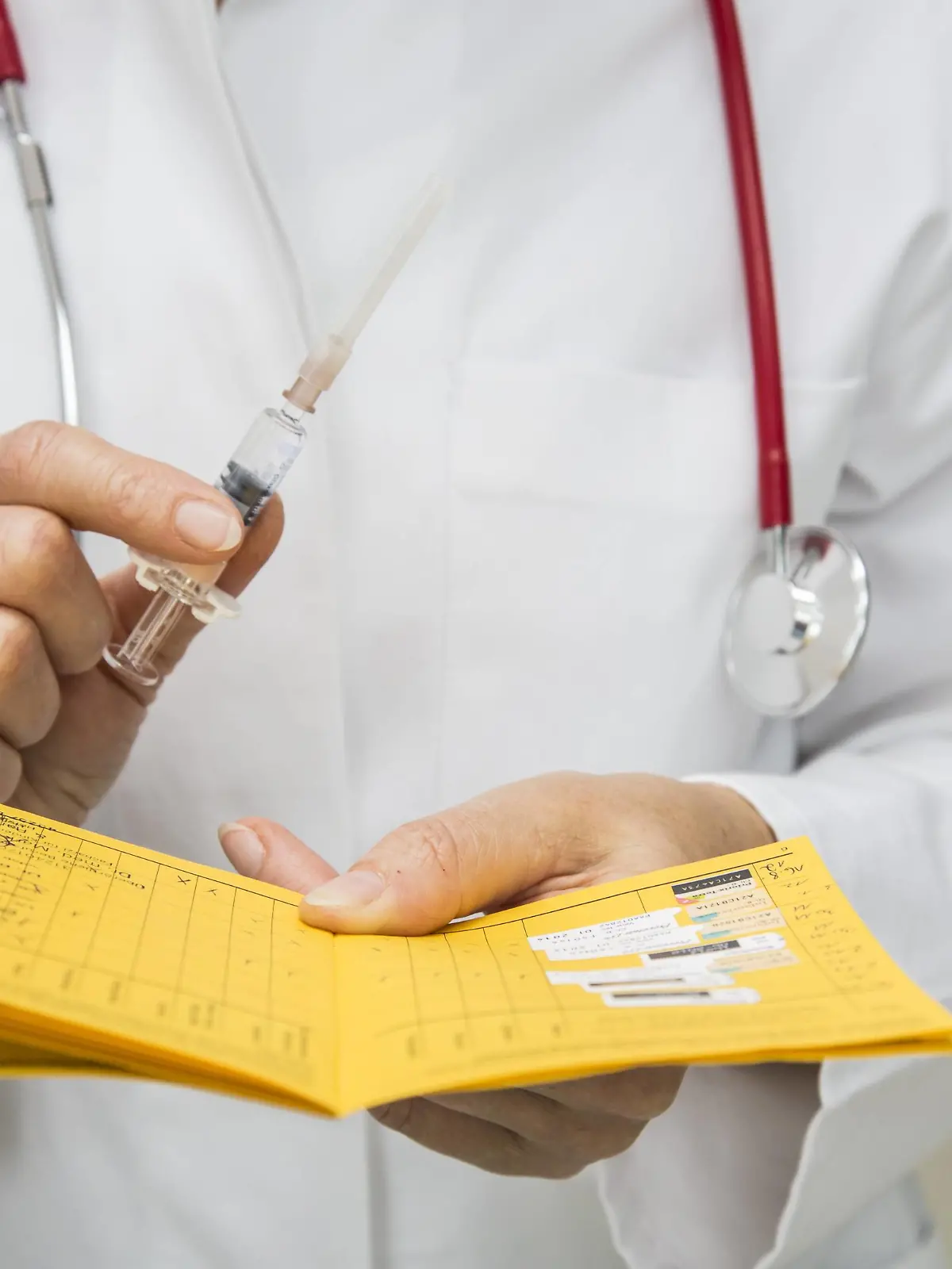 Symbolbild Medizin. Impfpass mit Spritze, Einmalverpackung, Auffrischungsimpfung gegen Diphtherie, Tetanus und PertussisSymbol image Medicine Vaccination with Syringe Once packaging  against Diphtheria Tetanus and pertussis