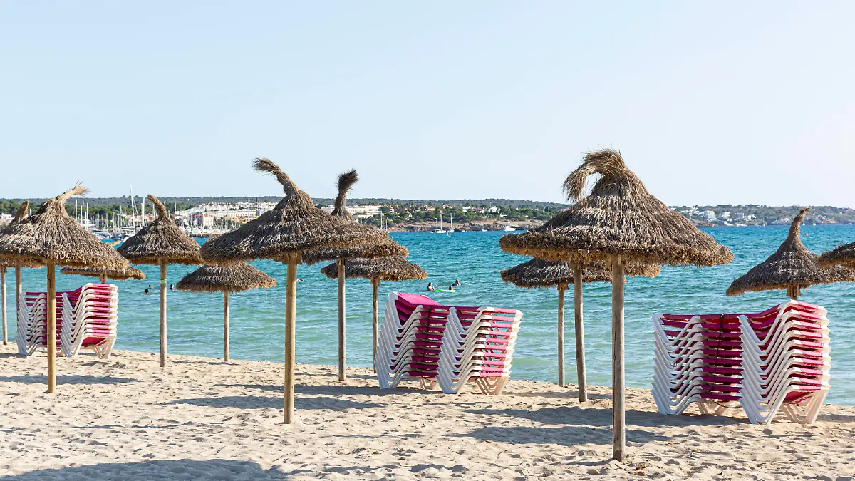 SPANIEN, MALLORCA, PALMA DE MALLORCA, 07.08.2020 - Gestapelte Sonnenliegen und Sonnenschirme an einem leeren Strandabschnitt der Playa de Palma in der Abendsonne am frühen Abend. Im Vergleich zu den Vorjahren sind weniger Touristen vor Ort. Grund ist die aktuell herrschende Corona-Pandemie. *** SPAIN, MALLORCA, PALMA DE MALLORCA, 07 08 2020 Stacked sun loungers and parasols on an empty beach section of Playa de Palma in the evening sun in the early evening Compared to previous years there are fewer tourists on site Reason is the current Corona Pandemic