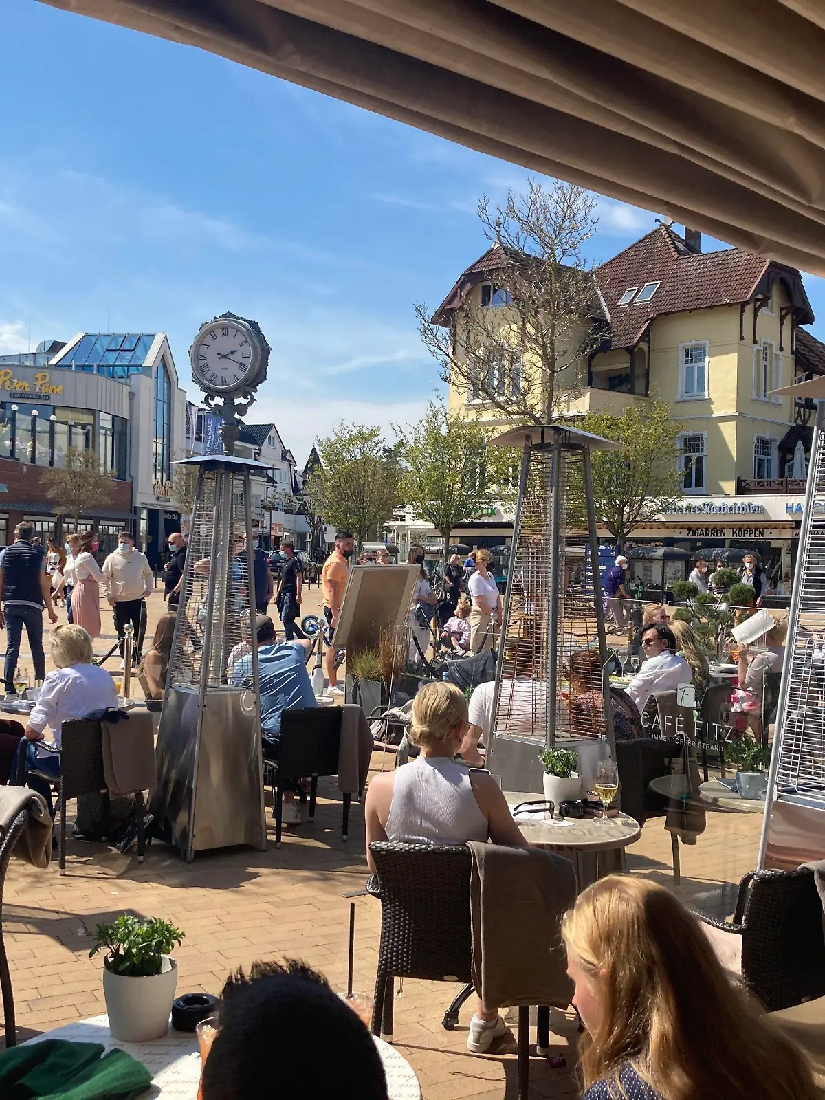09.05.2021, Schleswig-Holstein, Timmendorfer Strand: Zahlreiche Gäste sitzen in einem Cafe an der Lübecker Bucht. Seit Samstag, 8. Mai 2021 sind die Tourismusangebote in der inneren Lübecker Bucht wieder für Gäste geöffnet. Die innere Lübecker Bucht ist die dritte von vier touristischen Modellregionen Schleswig-Holsteins, in denen wieder Restaurantbesuche und touristische Übernachtungen möglich sind. Dabei gelten strenge Hygieneauflagen. Foto: Thomas Müller/dpa +++ dpa-Bildfunk +++