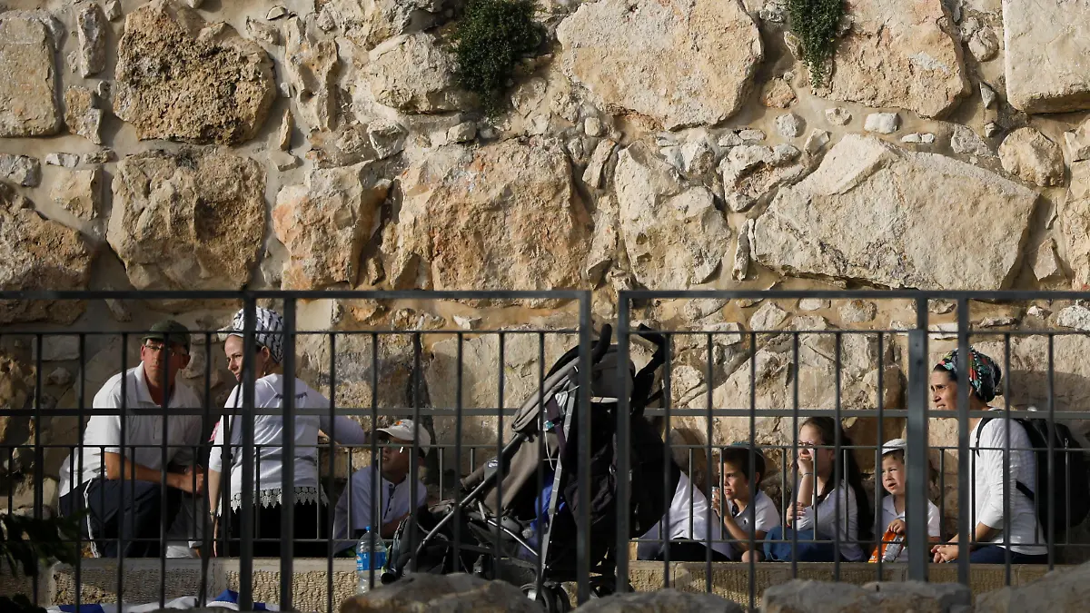 People take cover as a siren sounds warning of incoming rockets, amid Israeli-Palestinian tension, on Jerusalem Day, near the wall surrounding Jerusalem's Old City May 10, 2021. May 10, 2021. REUTERS/Nir Elias