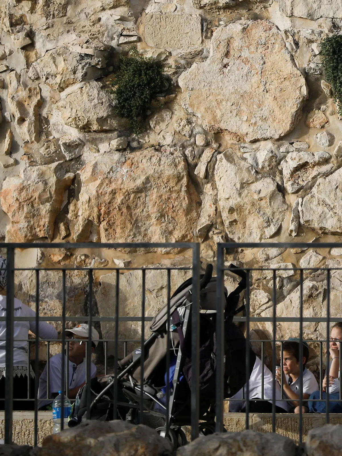 People take cover as a siren sounds warning of incoming rockets, amid Israeli-Palestinian tension, on Jerusalem Day, near the wall surrounding Jerusalem's Old City May 10, 2021. May 10, 2021. REUTERS/Nir Elias