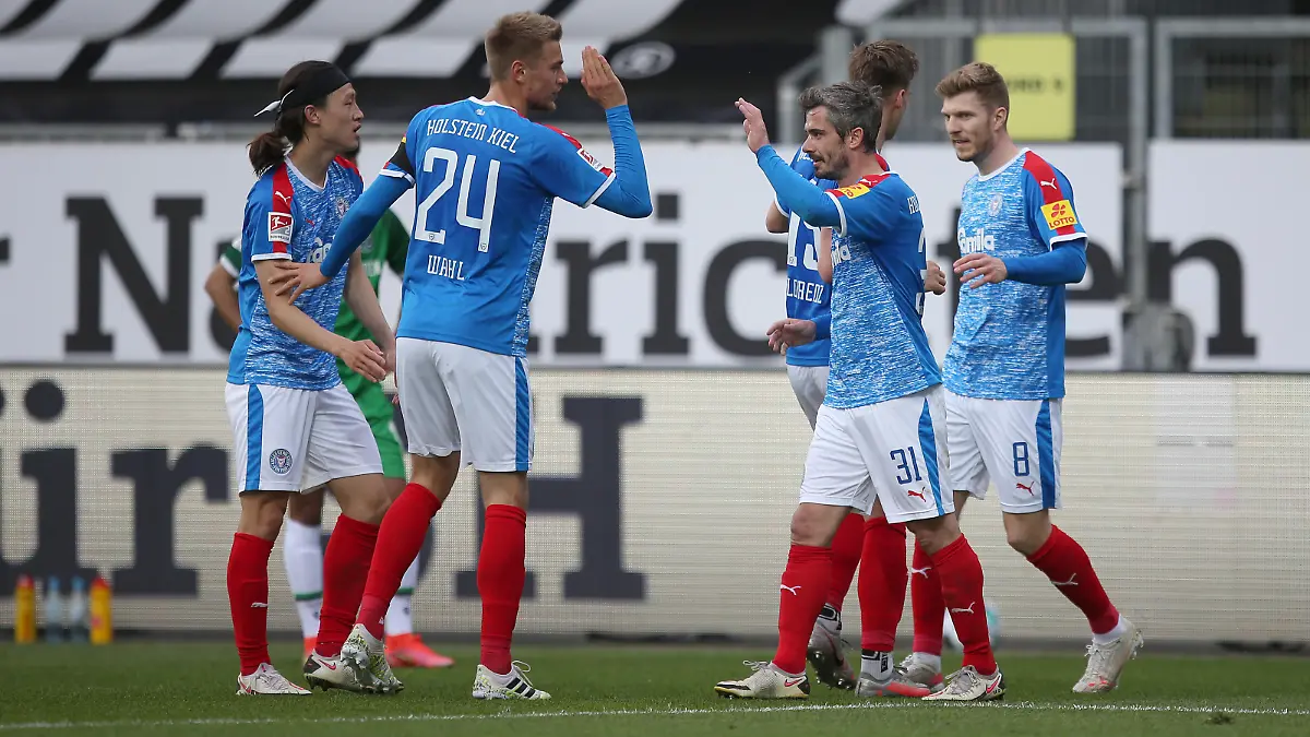 KIEL, GERMANY - MAY 10: Fin Bartels (2nd L) and his teammates of Holstein Kiel celebrate after scoring during the Second Bundesliga match between Holstein Kiel and Hannover 96 at Holstein-Stadion on May 10, 2021 in Kiel, Germany. (Photo by Cathrin Mueller/Getty Images)