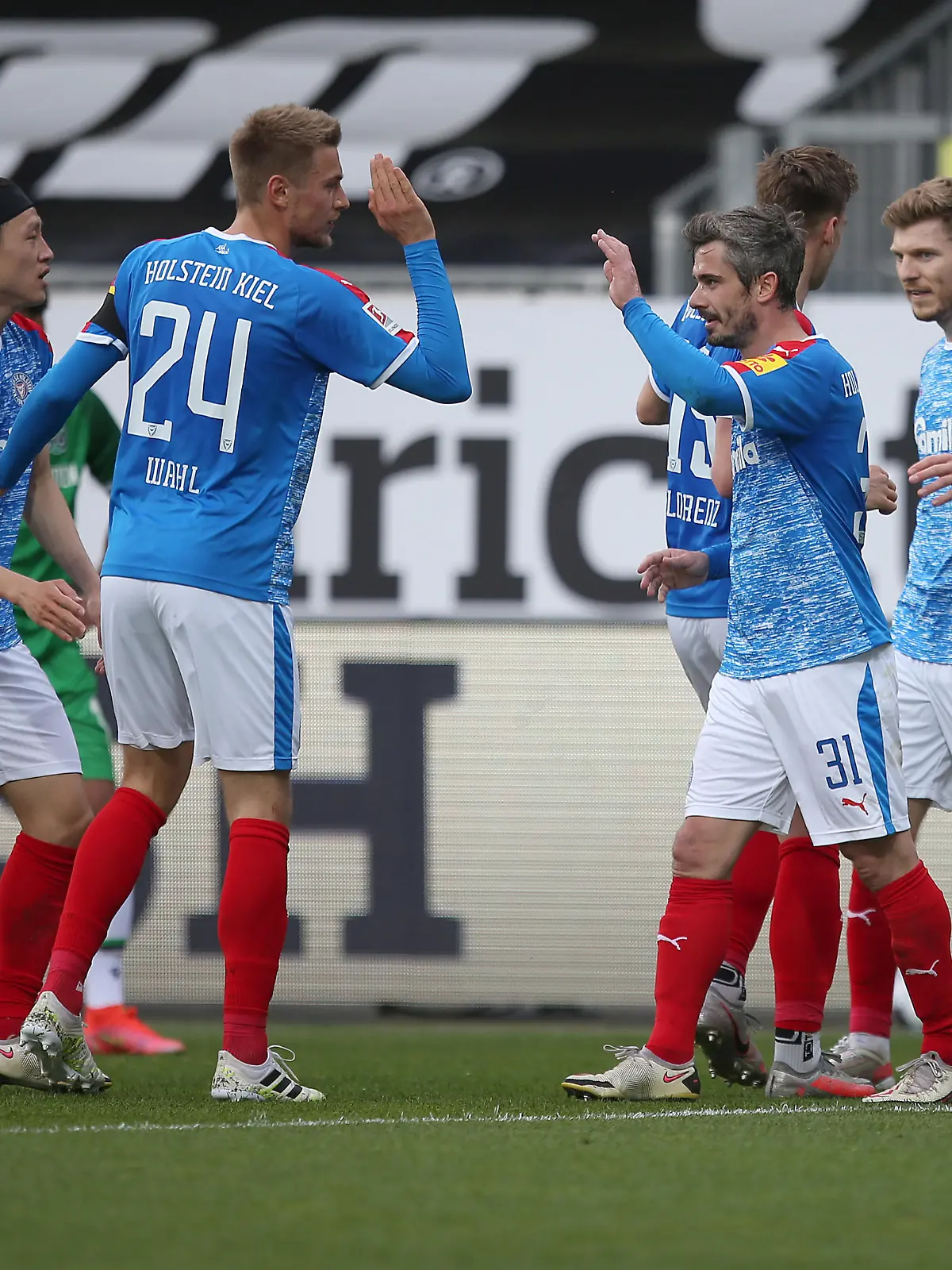 KIEL, GERMANY - MAY 10: Fin Bartels (2nd L) and his teammates of Holstein Kiel celebrate after scoring during the Second Bundesliga match between Holstein Kiel and Hannover 96 at Holstein-Stadion on May 10, 2021 in Kiel, Germany. (Photo by Cathrin Mueller/Getty Images)