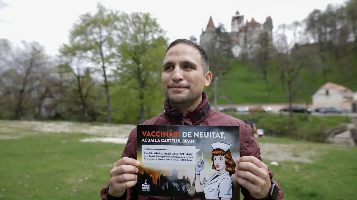 Fernando Orozco poses with a mock diploma attesting his vaccination against the coronavirus disease (COVID-19) at the temporary vaccination center at Bran Castle, in Brasov county, Romania, May 8, 2021. Inquam Photos/George Calin via REUTERS ATTENTION EDITORS - THIS IMAGE WAS PROVIDED BY A THIRD PARTY. ROMANIA OUT. NO COMMERCIAL OR EDITORIAL SALES IN ROMANIA