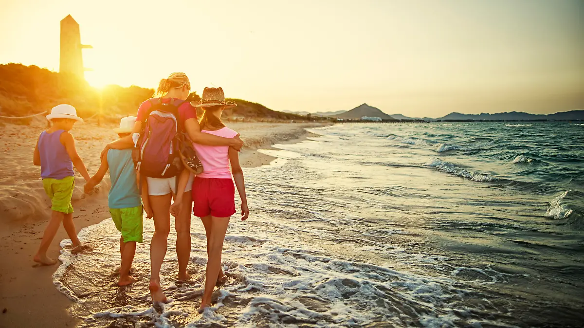 Familie geht am Strand in Spanien spazieren.