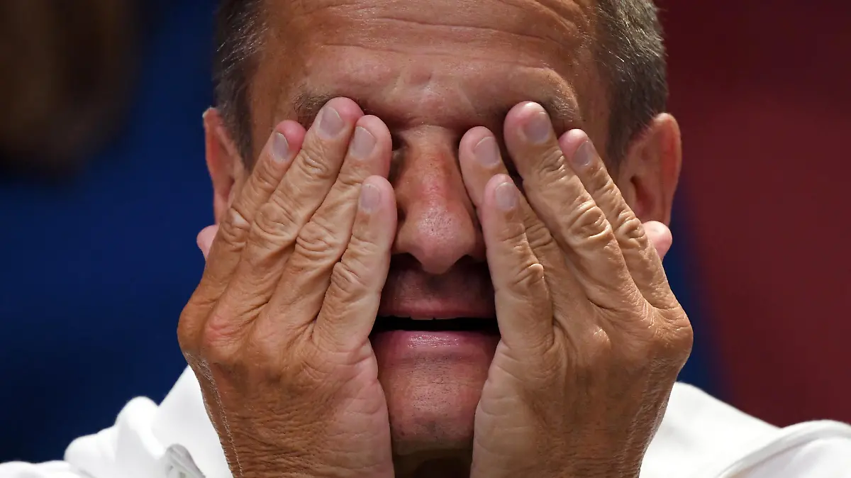 06.05.2021, Nordrhein-Westfalen, Düsseldorf: Alfons Hörmann, Präsident des Deutschen Olympischen Sportbundes (DOSB), wischt sich bei der offiziellen Präsentation der Outfits für die deutsche Olympia- und Paralympia-Mannschaft  das Gesicht ab. Bei der digitalen Veranstaltung wird die Kollektion für Tokio 2020 von Athleten des Team Germany und des Team Germany Paralympics präsentiert. Foto: Ina Fassbender/AFP POOL/dpa +++ dpa-Bildfunk +++