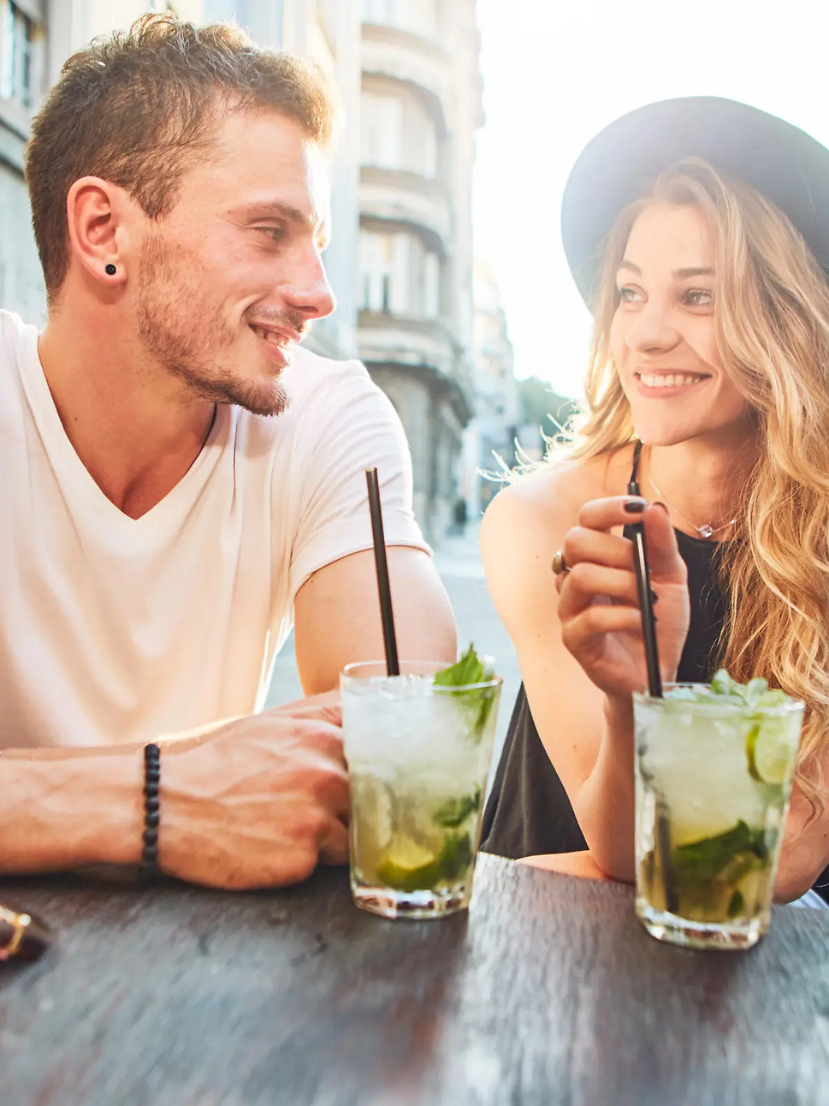 Junges Paar trinkt Cocktails und hat gute Laune