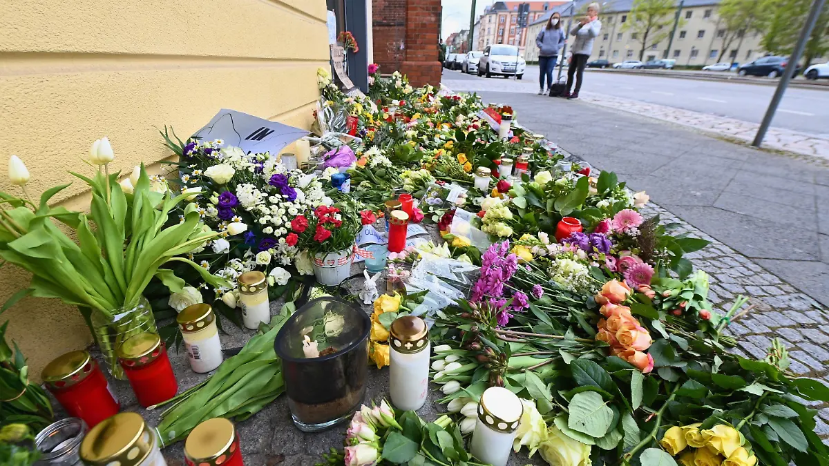 30.04.2021, Brandenburg, Potsdam: Blumen, Kerzen und Plakate liegen vor dem Eingang zur Einrichtung des diakonischen Anbieters Oberlinhaus. In der Einrichtung mit einem Wohnheim waren am 28.04.2021 vier Leichen und eine schwer verletzte Person gefunden worden. Zum Oberlinhaus gehören neben Einrichtungen für Menschen mit Behinderung auch eine Schule und eine Orthopädische Fachklinik. Foto: Soeren Stache/dpa-Zentralbild/dpa +++ dpa-Bildfunk +++