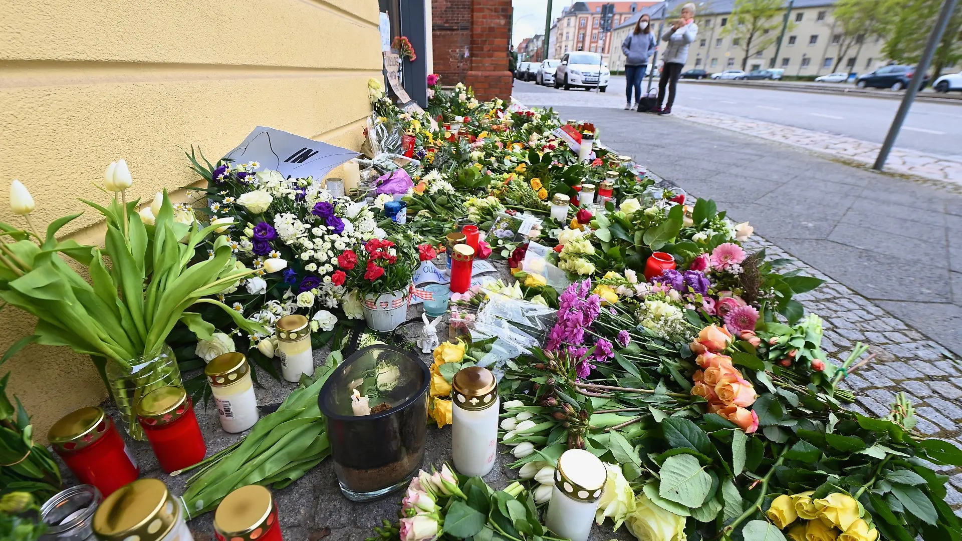30.04.2021, Brandenburg, Potsdam: Blumen, Kerzen und Plakate liegen vor dem Eingang zur Einrichtung des diakonischen Anbieters Oberlinhaus. In der Einrichtung mit einem Wohnheim waren am 28.04.2021 vier Leichen und eine schwer verletzte Person gefunden worden. Zum Oberlinhaus gehören neben Einrichtungen für Menschen mit Behinderung auch eine Schule und eine Orthopädische Fachklinik. Foto: Soeren Stache/dpa-Zentralbild/dpa +++ dpa-Bildfunk +++