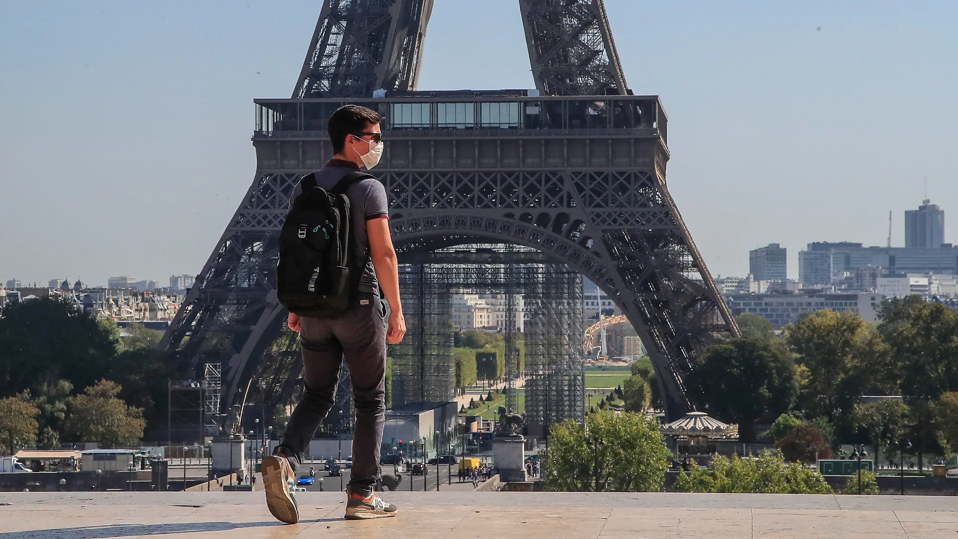 14.09.2020, Frankreich, Paris: Ein Passant geht mit Mundschutzmaske über den Place du Trocadéro, während im Hintergrund ein Teil des Eiffelturms zu sehen ist. Frankreich hat am 13. September die Schwelle von 10 000 Corona-Infektionen an einem Tag überschritten. Foto: Michel Euler/AP/dpa +++ dpa-Bildfunk +++