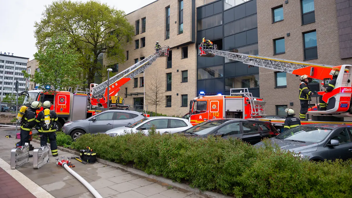 ARCHIV - 01.05.2020, Hamburg: Zwei Drehleitern und mehrere Einsatzfahrzeuge stehen vor einem Wohnhaus. Weil er seine Ex-Frau mit einem Messer angegriffen und sie sowie einen Sohn mit Benzin übergossen und angezündet haben soll, muss sich ein 50-Jähriger vor dem Hamburger Landgericht verantworten. Die Strafkammer will am 04. Mai 2021 ihr Urteil verkünden. (zu dpa «Urteil erwartet in Prozess um Mordversuch - Frau und Sohn angezündet») Foto: Jonas Walzberg/dpa +++ dpa-Bildfunk +++
