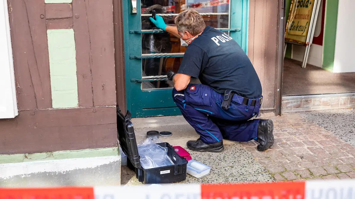 15.09.2020, Niedersachsen, Celle: Ein Mitarbeiter der Spurensicherung arbeitet vor einem Juweliergeschäft. Gestern haben zwei bewaffnete Männer versucht, einen Juwelier zu überfallen. Beide Täter wurden tödlich verletzt. Nach bisherigen Erkenntnissen hatte der Ladeninhaber eine Waffe, die er gegen die Räuber einsetzte. Foto: Moritz Frankenberg/dpa +++ dpa-Bildfunk +++