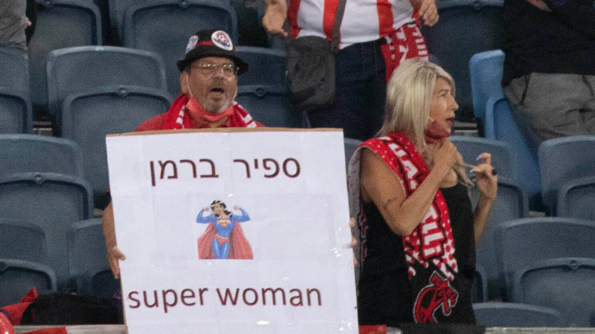 A fan holds a sign with the name of referee Sapir Berman during an Israeli Premier League soccer match between Hapoel Haifa and Beitar Jerusalem in the northern Israeli city of Haifa, Monday, May 3, 2021. Israeli soccer's first transgender soccer referee took the field Monday for the first time since coming out publicly as a woman last week. (AP Photo/Sebastian Scheiner)