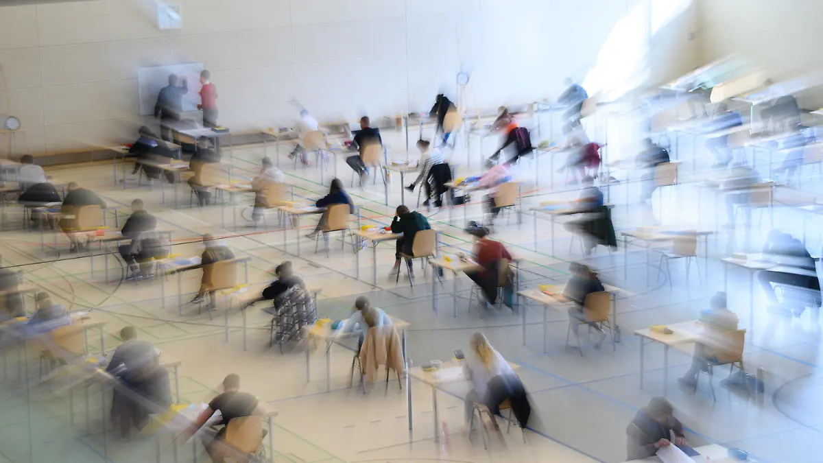 30.04.2021, Sachsen, Dresden: Mit weitem Abstand sitzen Schüler des Gymnasiums Bürgerwiese zur Abiturprüfung in Deutsch an ihren Tischen in der Sporthalle. Foto: Robert Michael/dpa-Zentralbild/dpa +++ dpa-Bildfunk +++