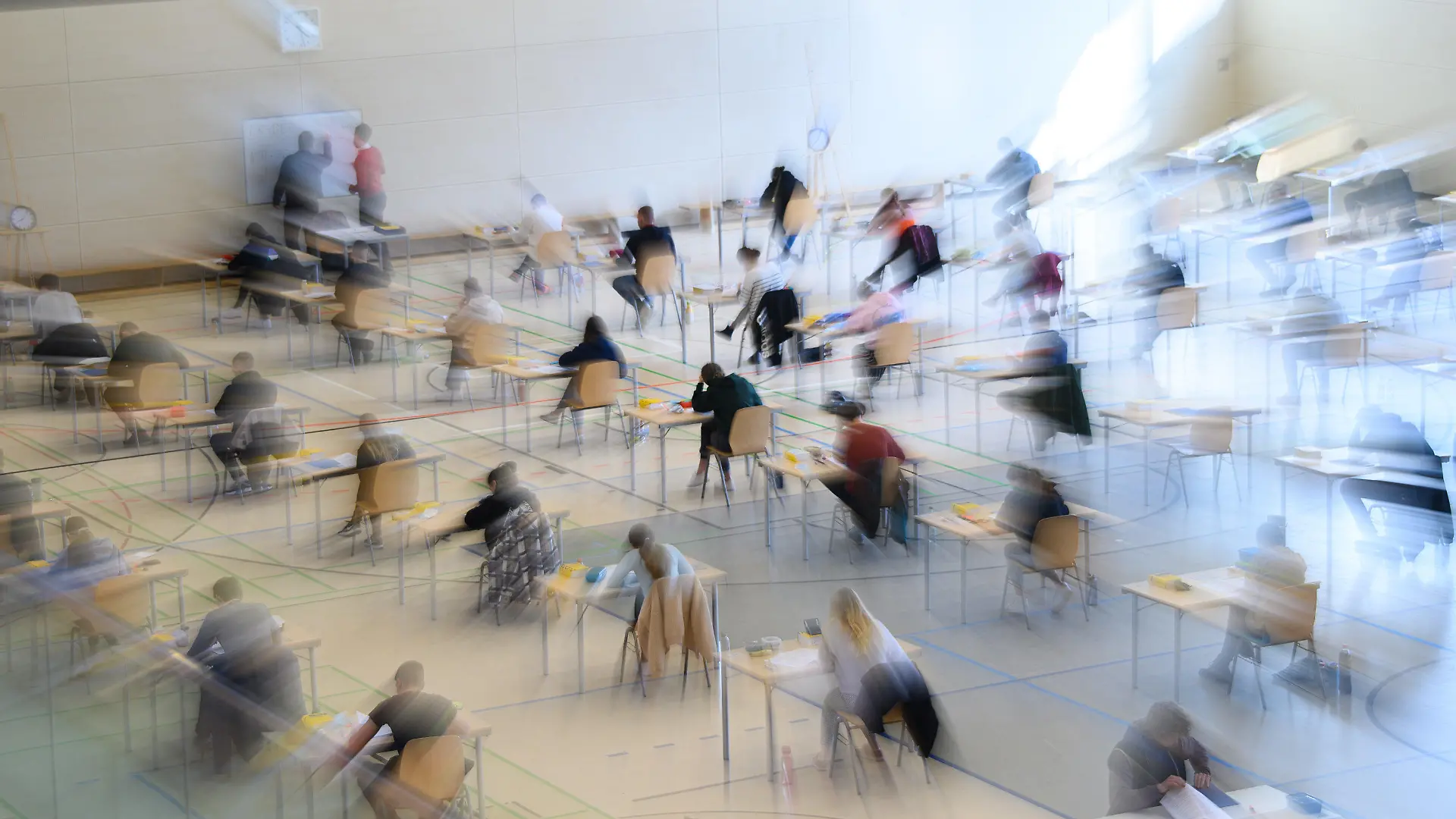 30.04.2021, Sachsen, Dresden: Mit weitem Abstand sitzen Schüler des Gymnasiums Bürgerwiese zur Abiturprüfung in Deutsch an ihren Tischen in der Sporthalle. Foto: Robert Michael/dpa-Zentralbild/dpa +++ dpa-Bildfunk +++