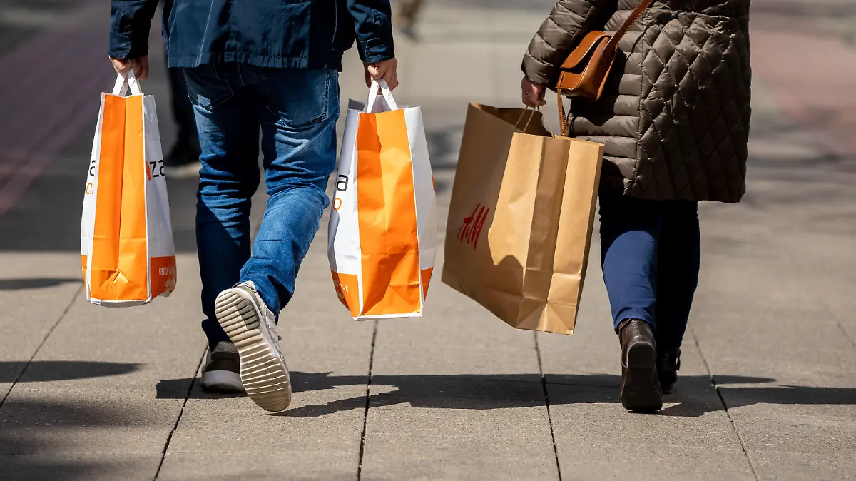 26.04.2021, Niedersachsen, Hannover: Passanten gehen mit Papiertüten in den Händen durch die Innenstadt. Foto: Moritz Frankenberg/dpa +++ dpa-Bildfunk +++