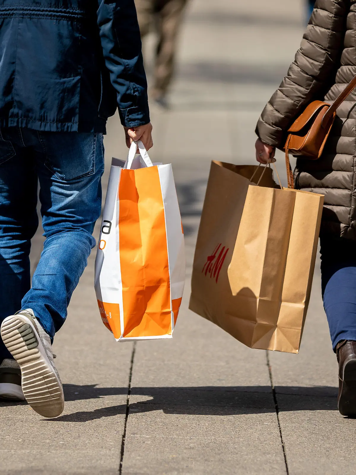 26.04.2021, Niedersachsen, Hannover: Passanten gehen mit Papiertüten in den Händen durch die Innenstadt. Foto: Moritz Frankenberg/dpa +++ dpa-Bildfunk +++